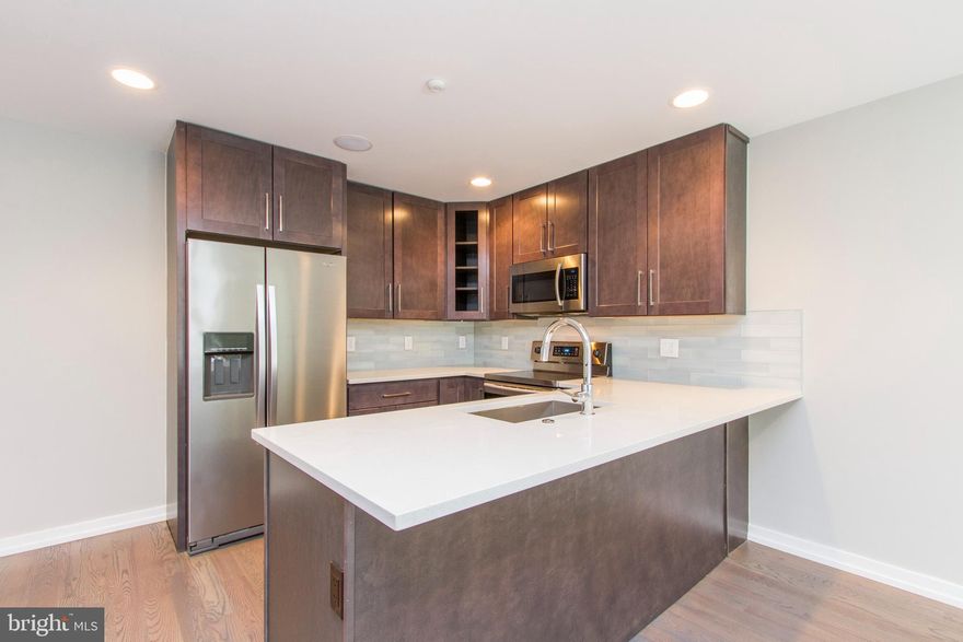 A gorgeous unit that's ready and waiting to be called home! Enter this bi level unit and discover the hardwood flooring, recessed lighting, high ceilings with installed speakers, and large energy efficient windows which provide ample natural light. The spacious, open living and dining space offers plenty of room for entertaining friends and family, and showcases the gorgeous kitchen, which includes granite counters and large island, stainless steel appliances, and a beautifully tiled backsplash. Continue past the kitchen to find the beautifully tiled bathroom with tub and shower combo, and separate stall shower with frameless glass enclosure, both with dual shower heads. The floor also includes a sun drenched bedroom with a walk in closet and access to a patio- just the spot for lounging on those sunny days! Downstairs features two lovely ensuite bedrooms with custom tiled bathrooms and stall showers with frameless glass enclosures. Washer and dryer are included in the unit, as well as an installed security system, and the location can't be beat- close to shops, restaurants, not to mention just minutes away from Center City. Don't wait, see this unit today!