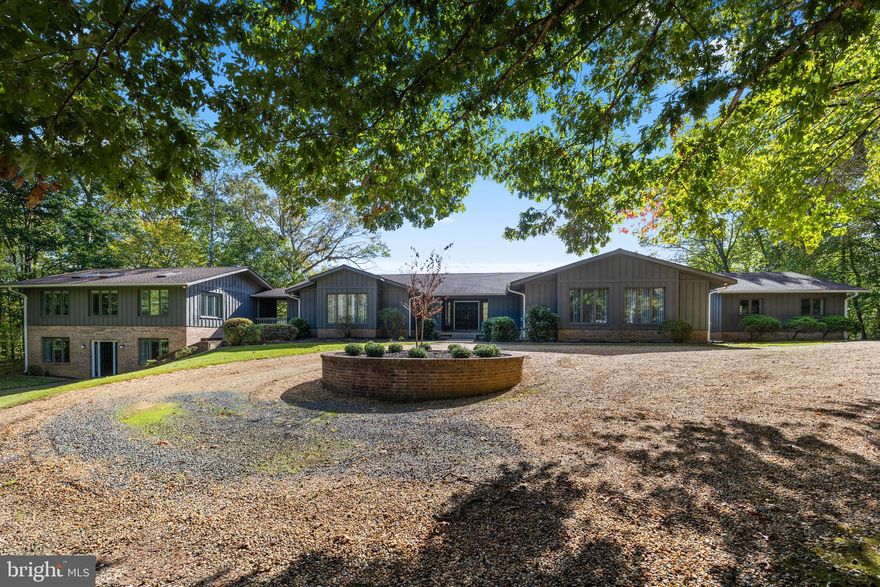 Sitting on almost six wooded acres, this beautiful custom-built home with a three-car garage, has a separate addition for extended family, guests, or home office.  The  main home features a great room with fireplace, a large kitchen/breakfast room, large laundry room, four generously-sized bedrooms, and four beautifully updated bathrooms. The master bedroom has separate his and her bathrooms with walk-in closets. A second spacious bedroom/den has its own bath. A third and fourth bedroom have a new Jack and Jill bath.  The spacious lower level offers unlimited potential, featuring three finished,multi-use rooms, a full bath, and three large storage areas, one of which includes workbenches and electrical outlets, perfect for hobbies or projects.  The separate addition which is accessible from the main house, has its own front entrance, offers living room, kitchen, breakfast area, three bedrooms, two full baths, and its own laundry room, providing a comfortable and private space.  Dogwood Air Park Association has a private runway for owners.  Owner financing is available to qualified buyers.