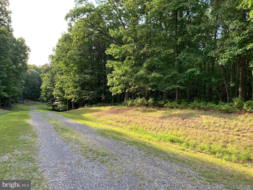 This is an excellent lot to build that special home on with maintained roads, underground utilities and fantastic views. This 3.86 acre wooded lot fronts on two streets in this beautiful and well maintained sub-division. There are 2 common areas with lakes for fishing. Great Location with trees all around. Just minutes to CaCapon State Park  and 10 miles south of Historical  Berkeley Springs. 3 miles from the VA and WV line.