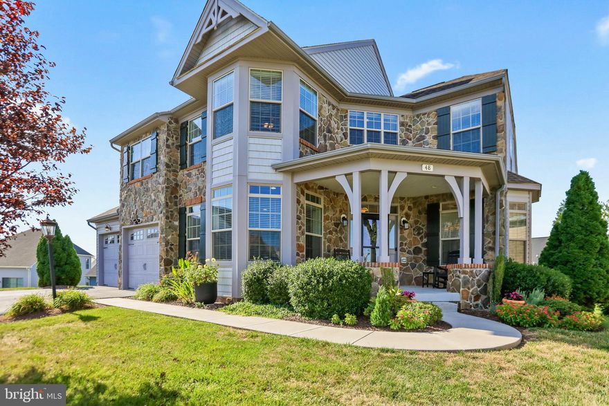 Welcome to 48 Thomas Beall Court, an elegant stone-front residence tucked within the gated community of Beallair in historic Charles Town. Offering 6 bedrooms and 4.5 baths across three finished levels, this exceptional home combines architectural sophistication, thoughtful updates, and sweeping views of the Blue Ridge Mountains.

From the moment you step inside, arched transitions, detailed trim, and hardwood flooring set a refined tone. A dramatic two-story family room with vaulted ceilings, skylights, grand crown molding, and a striking stone fireplace creates a show stopping centerpiece. The heart of the home is the gourmet kitchen, granite countertops, a tile backsplash, stainless steel appliances, and a spacious breakfast area with direct access to the screened-in Trex deck. Formal living and dining rooms and a private home office provide flexibility for both gatherings and quiet retreat.

The main-level primary suite offers comfort and privacy with dual walk-in closets and a soaking tub, separate shower, and dual vanities. On the upper level are three generously sized secondary bedrooms, one with an en suite full bath, a full hall bath, and a bright loft-style sitting area. The finished walkout lower level expands your living options with a dedicated home theatre room, recreation room anchored by a second fireplace, 2 additional bedrooms, a full bath, and an additional multi-purpose room.  The updated wet bar adds a luxurious touch with a granite countertop, KitchenAid mini fridge and ice machine, and a reverse osmosis water system. 

Indulge in refined outdoor living with an expansive screened porch, sun-drenched open deck, elegant stamped concrete patio, and a relaxing hot tub, all overlooking a newly fenced backyard. Mature evergreens, thoughtfully positioned, create a natural sanctuary that provides complete seclusion—offering what may be the only yard in the neighborhood with this level of privacy.

Recent enhancements further elevate the home’s comfort and style, including a new HVAC system (2024), a custom front storm door, a sleek new dishwasher, premium updated screens on all main level deck windows and doors, and sophisticated finishes at the upgraded wet bar.

Beallair offers residents a low-maintenance lifestyle with lawn care, landscaping, and snow removal included in the HOA, plus walking and biking paths and a welcoming calendar of community events. Located minutes from the MARC train, major commuter routes, Harpers Ferry, and the shops and dining of downtown Charles Town, this location offers both tranquility and convenience. Elegant and inviting, 48 Thomas Beall Court is ready to deliver the comfort, space, and refined lifestyle you’ve been searching for.