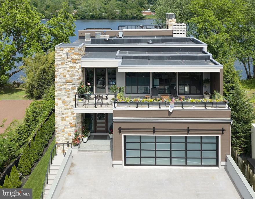 Modern Riverfront Estate with Unparalleled Indoor-Outdoor Living

Welcome to 182 S. Main Street, a rare opportunity to own one of New Hope’s few new-construction riverfront estates. Built in 2021 with every luxury in mind, this architectural showpiece blends cutting-edge design with the timeless allure of life along the Delaware River.

From the moment you enter the two-story foyer, you’re met with sweeping river views that flow throughout the home’s open living spaces. The main level features radiant-heated floors, a chef’s kitchen with  Sub-Zero refrigerators, wine refrigerator, and Wolfe gas stove and double ovens with warming drawer, plus a wet bar with sink, refrigerator, and ice maker—ideal for entertaining in every season. The adjoining family room opens to a spacious riverfront terrace, creating an effortless connection between indoor and outdoor living that is truly unparalleled. Additionally there is a half bath and laundry on the main level. 

The primary suite on the main level serves as a private retreat, complete with two large walk-in closets—one showcasing a sparkling chandelier and built-in TV for a touch of glamour—along with a spa-inspired bath.

Upstairs, you’ll find three additional bedroom suites, each with a private bath, as well as a dedicated office and an expansive family/media room with bar and an additional half bath and laundry. The upstairs bathrooms feature radiant-heated porcelain floors, and the family room boasts a 100-inch drop-down screen, wet bar with ice maker, microwave, refrigerator, and dishwasher, and panoramic river views. This versatile upper level can function as a private living area for family or  guests, with both front and rear terraces extending the space outdoors. 

The home’s roof deck offers one of New Hope’s most exceptional outdoor living experiences—a dramatic vantage point complete with a fireplace and unrivaled views of the river and fireworks, making it one of the area’s most spectacular private spaces.

The lower level continues the sense of luxury with 10-foot ceilings and radiant-heated floors throughout. The media and game room opens to a covered patio with built-in heaters and a private hot tub overlooking the water. From here, a floating dock provides direct access for boats and two jet skis, making river recreation effortless.

Car enthusiasts will appreciate the innovative car-lift system connecting the main-level garage to the lower level, accommodating four vehicles below, one on the lift, and two in the main garage—plus parking for five additional cars in the driveway. A large storage space beneath the driveway provides ample room for summer gear, river toys, and seasonal décor. There is also an additional storage space that has a garage door to the backyard, great for bringing water toys in or versatile storage space. 

Additional features include:
• Fully integrated smart-home system controlling lights, shades, and sound throughout
• Hardwired indoor and outdoor speaker system
• Professionally landscaped riverfront grounds

With its unmatched combination of design, technology, and river access, 182 S. Main Street stands as one of New Hope’s most remarkable modern estates—offering unparalleled indoor-outdoor living just steps from the heart of downtown.