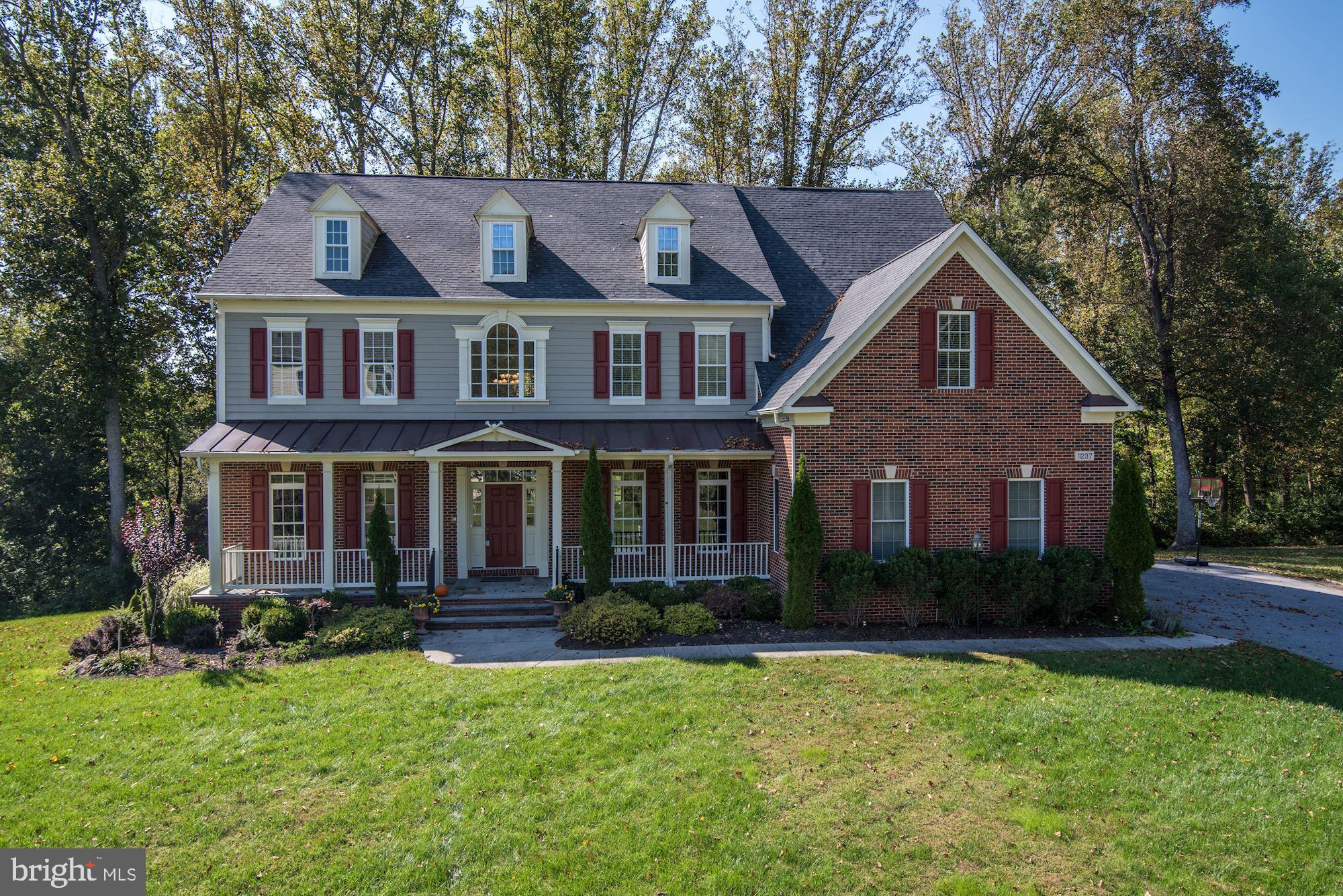This picturesque home is located in the exclusive neighborhood of Riverwood, offering a stately brick front and manicured landscaping. Situated on a premium lot with over an acre of land, and nestled at the end of a lovely cul-de-sac, this home offers a private retreat with a tiered deck and screened in area facing a nature preserve. In fall and winter you have lovely views of Middle Patuxent River and in summer lush forest. You always have the peace of mind knowing no building is permitted behind your home and treasured lot. A welcoming covered stone front porch boasts upgraded slate and is oversized with plenty of room for exterior seating. The dramatic two story entry foyer is sided by light-filled living and dining formals in a stunning open plan design that is perfect for welcoming guests and entertaining. The formal dining room is generously proportioned to create a fine dining experience with a full wet bar and butler's pantry to support gatherings large and small. A lavish extended foyer unfolds into a two story great room soaring twenty feet to the ceiling with a feature stone fireplace flanked by stacked windows and transoms that frame breathtaking views of the surrounding nature preserve. Adjacent to the great room is a secondary back stair, followed by a gourmet kitchen hosting a hallmark center entertainers island, with decorative pendants above and forty-four square feet of granite for meal prep, gatherings and festivities all year round. This is truly a cooks kitchen combining modern elegance with comfort, style, and amenities including stainless steel appliances, pot-filler, designer back splash, baseboard kick-vacuum, instant hot water, and a walk-in pantry. Relax and decompress any time of day and experience the peaceful setting with great views of the exterior woodlands from the two tiered deck while you prep your favorite BBQ and dine comfortably in the screened in deck area. Work at home with ease and efficiency in a private office bathed in natural light, and enclosed by French doors, or, convert this to accessible main level space to a sixth bedroom. The main level is also abundantly outfitted with a private planning station, perfect for work or study, a mud room with built-in cubbies, and a laundry center with hook-up, cabinetry and folding counter. Adjacent to the mud room, an arrival entry hall from the side load garage is clad in a substantial tile wainscoting and decorative pencil cap that will stand up to every-day in/out traffic, luggage, back packs and sports equipment. Upstairs the owners' suite is located in a private wing near the back stair. Retreat to spa-like luxury bath with a Roman soaking tub, separate vanities, walk-in shower, dual shower heads, a private water closet, and finally, enjoy the space of two walk-in closets as well as a very large bonus dressing closet that will accommodate any wardrobe. On the opposite side of the upper hall, there is a second laundry hook-up and there are four additional en-suite bedrooms, each with a private bath and walk-in closet. Downstairs, lower level living offers a walk-out slider with full daylight to enhance a spacious recreation room, game area, a fifth bedroom, full bath, and theater room which will include projector and sound system. Live, work and entertain with flexibility and options inside and outside, combined with fine finishes and luxury amenities at every turn. PLEASE NOTE: THIS HOME HAS A PRIVATE SEPTIC SYSTEM. NO ADDITIONAL FEES!
