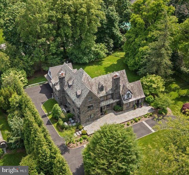 An exceptional opportunity awaits with this exquisite stone manor home, spanning over 6,000 sq. ft in prime North-Side Haverford, Lower Merion Township. Meticulously renovated, curated to perfection and prominently set on one of the finest and most sought-after streets in the township offering remarkable curb appeal, unparalleled privacy, and a setting reminiscent of a luxury resort. Sun-drenched, turnkey luxury living awaits in this magnificent six-bedroom Main Line Manor Home combining historic provenance with contemporary designer style thanks to a meticulous expansion and renovation. Masterfully curated and re-designed by Main Line designer Fiona Moshal Interiors, this 6,300 +/- square-foot sanctuary delivers a magazine-worthy transitional aesthetic throughout. Tall ceilings soar above new chevron French oak hardwood floors, architecturally significant Marvin true divided light windows, restored original stained glass, handsome millwork, dazzling designer lighting, and a wealth of curated stone, including marble, granite and onyx. A flagstone terrace running the length of the house and beautiful arched entry door welcome you inside to OPEN curated spaces that elevate the classic center hall design with seamless indoor-outdoor circular flow ideal for intimate gatherings and large-scale entertaining. Relax in front of the marble fireplace in the formal living room, and enjoy a stunning home office with stone walls, verdant views and access to the front terrace. Plan your next dinner party in the formal dining room, ideally located next to a world-class gourmet kitchen, where imported stone counters, marble tile backsplashes, and a waterfall island/breakfast bar surround maple cabinetry. Chefs will love the upscale stainless steel Viking Professional Kitchen appliances with six-burner range, hood, convection ovens, microwave and warming drawer + Bosch DW, and Scotsman ice maker. Accessed from the open kitchen, the sunken family room is sure to be a favorite gathering spot thanks to it's built-in cabinetry, surround-sound television, and direct access to the incredible rear yard. Claim this manicured oasis just in time for summer entertaining on the expansive flagstone patio finished with a plumbed gas grill. In this completely private and peaceful retreat you're surrounded by irrigated landscaping and hardscaping, garden sculptures, specimen plantings and black estate fencing. A guest powder room with an illuminated onyx vanity, a mudroom entry, laundry room and second powder room complete the main level. Head to the finished walkout lower level to explore an entertainer’s dream space anchored by an illuminated onyx walkup bar with wine refrigerator, ice maker, and adjacent temperature-controlled wine room. Gather around the fireplace and enjoy epic movie nights in the open theater area. Two storage rooms and a gym with rubber flooring and mirrored wall add wonderful convenience. Ascend the work-of-art staircase flanked by reimagined stained glass windows to explore the second floor’s luxurious accommodations, beginning with an owner’s suite featuring two walk-in closets and an en suite spa bathroom with a steam shower, deep soaking tub, Toto water closet, linen closet and separate quartz vanities. Two secondary suites on this floor boast private baths and walk-in closets. On the top floor, you’ll find a third secondary suite and two bedrooms sharing a Jack-and-Jill bath. This home’s extensive upgrades include smart home automation with iPad screens, Lutron lighting and window shade controls, and five-zone high-efficiency HVAC. Built in 1927, this stately manor’s all-stone facade, slate roof and copper gutters add magnetic curb appeal, while also including a Belgian block-lined circular drive, motor court, 2 car garage w/ tall ceilings and EV charger. Enjoy easy access to Top-Rated Lower Merion schools, colleges, the famed Merion Cricket Club, the Haverford train station, and an array of restaurants & boutiques.