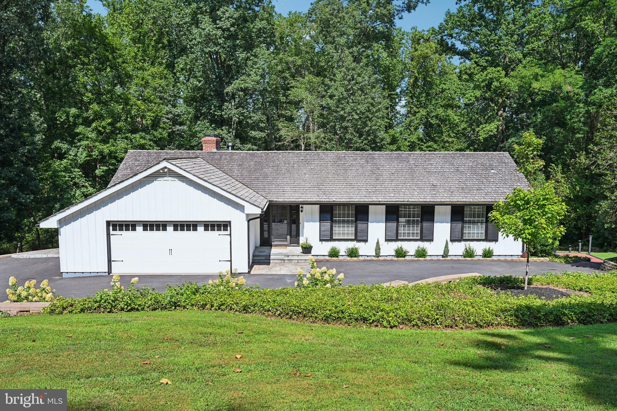 A Tranquil Retreat in New Hope-Solebury
Nestled on over two lush acres in the highly acclaimed New Hope-Solebury School District, this beautifully updated 4-bedroom, 3-bathroom ranch offers the perfect blend of privacy, space, and convenience. Located just minutes from the charm of New Hope Borough and the attractions of Peddler’s Village, this home is a serene escape in one of Bucks County’s most desirable locations.
Step inside to a welcoming entry that opens into a thoughtfully designed interior where comfort meets functionality. The main living spaces have been transformed into an expansive great room—perfect for entertaining and everyday living. The beautifully updated kitchen features sleek new cabinetry, quartz countertops, a statement exhaust hood, stainless steel appliances, and an oversized center island with additional storage. A large picture window frames picturesque views of the private backyard, inviting natural beauty indoors. Adjoining the kitchen is a cozy breakfast room with a wood-burning fireplace, adding warmth and character. The spacious primary suite offers breathtaking views and direct access to a raised deck overlooking the backyard. The en suite bath is fully updated with a luxurious walk-in shower, an oversized vanity, and ample closet space. Three additional generously sized bedrooms share a modern, updated hall bathroom. A main-level laundry room leads to the finished, above-grade lower level—complete with a stylish entertaining area, decorative fireplace, private office, enclosed solarium, and a full bath with outdoor access. Step outside to discover an extraordinary outdoor oasis. From the raised deck to the expansive brick patio, the connection to nature is simply unmatched. Follow the winding path past a charming bridge to a peaceful gazebo—an idyllic spot for relaxation and reflection. An oversized two-car attached garage completes this exceptional property. With its prime location, versatile layout, and stunning natural setting, this home is ready for its next chapter. Enjoy easy access to top-rated schools, shopping, recreation, and major commuter routes. Schedule your private tour today and experience the beauty of Bucks County living!
