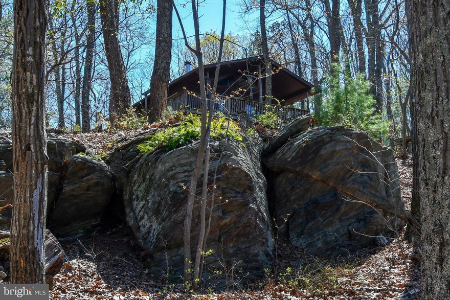 Escape to your own private mountain retreat on 10.76 acres of peaceful countryside. This charming home features a spacious wrap-around deck and stunning scenic views through oversized picture windows and sliding glass doors that bring the outdoors in. The spacious primary suite offers a walk-in closet and private bath for a relaxing retreat. A grand living room with a cozy wood stove opens to the rear deck and yard, creating the perfect space for entertaining or unwinding in nature. The property also includes four outbuildings, including a two-car garage ideal for storage, hobbies, or a workshop. Conveniently located just minutes from Route 66, Middleburg, and Great Meadows—this property offers the perfect balance of privacy and accessibility.