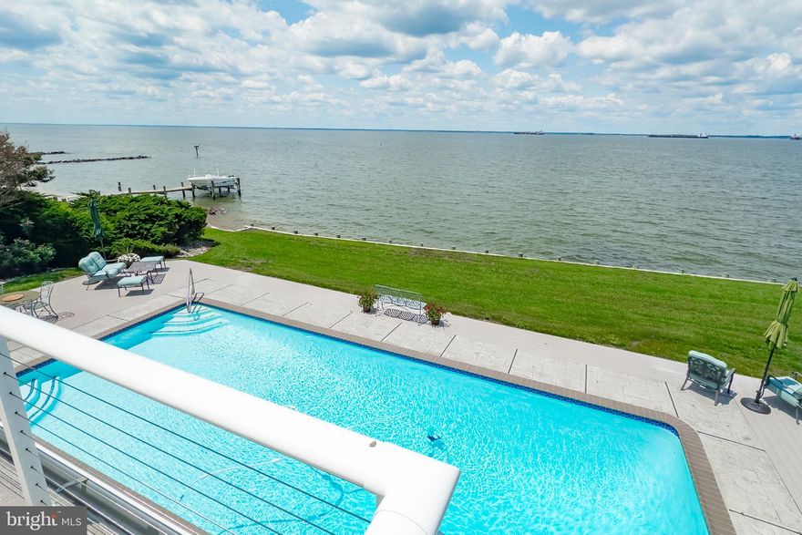 GORGEOUS VIEWS AND AMAZING SUNSETS!! Experience breathtaking Chesapeake Bay water views and evening sunsets from this  waterfront home! Boasting 4,298 sq. ft. of finished living space, this stunning property offers 135 ft of water frontage, an in-ground saltwater swimming pool, and large screened-in porch!  This home is a blend of elegance and comfort, perfect for those seeking a serene yet sophisticated lifestyle. The beautifully landscaped yard, coupled with direct access to the bay, offers endless opportunities for outdoor recreation and relaxation. Upon entering, you are greeted by an open floor plan, high cathedral ceilings, wood floors, and a floor-to ceiling brick fireplace. The spacious living areas seamlessly connect to the gourmet kitchen. The kitchen is complete with stainless-steel appliances, custom cabinetry and a large kitchen island perfect for entertaining. The home offers 5 Bedrooms with a potential 6th in the separate guest quarters. The primary suite features expansive windows that frame the stunning water views and a en-suite bathroom. Additional bedrooms provide ample space for family and visitors, ensuring comfort and privacy for all. Multiple improvements made including a renovation / addition in 2015 adding additional bedrooms or private guest quarters with its own entrance, 500 sq. ft of beautiful office space and storage! New HVAC systems (2023/2024) , replaced 135 foot 18” channel ward bulkhead (2021),  large generator (2015)  and much, much more!  The neighborhood is a wonderful water privileged community with marina and boat slips.  Don't miss the opportunity to make this home your own. Experience firsthand the beauty and the waterfront lifestyle  that await!