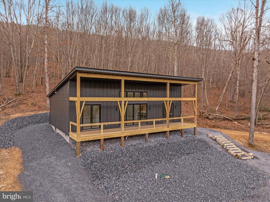 NEW CONSTRUCTION! 

Modern Mountain Retreat – 3 Bed | 2 Bath | 1,380 Sq Ft
Step into 1,380 square feet of thoughtfully designed modern living, where comfort meets nature. This 3-bedroom, 2-bathroom home abuts the serene backdrop of the George Washington National Forest and is just minutes from the Trout Pond Recreation Area, shopping and dining in Lost River Valley, and dining and organic farmers market in Wardensville. Perfect for outdoor enthusiasts seeking hiking, fishing, and boating adventures. The exterior features LP Smart-side siding and a sleek black metal roof, accented by a welcoming covered front porch—ideal for morning coffee or evening sunsets. Inside, the home dazzles with tongue-and-groove wood ceilings in the main living space, Pergo flooring that combines durability with style, and quality finishes and fixtures throughout. The modern kitchen is a chef’s dream, boasting custom cabinetry, quartz countertops, and all-new LG appliances. Relax in front of the electric fireplaces in both the living room and primary bedroom, adding warmth and ambiance year-round. Every detail in this home balances style and functionality, creating a seamless retreat from the everyday, all while keeping you connected to the stunning West Virginia landscape just outside your door.