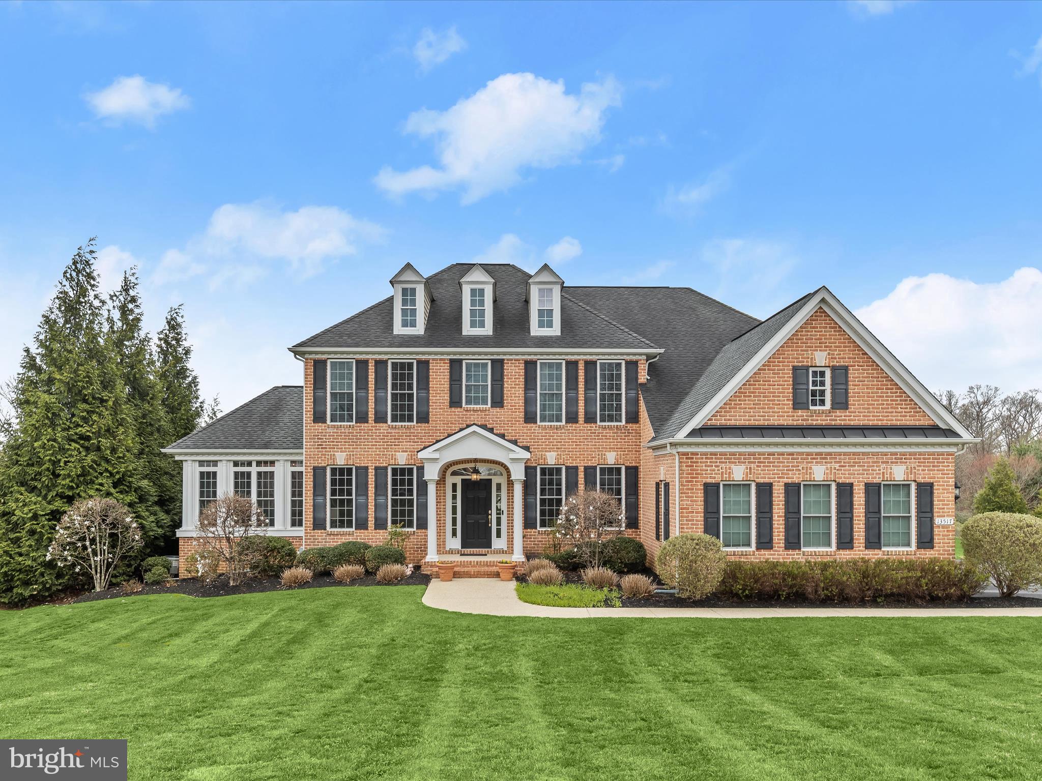 Welcome to 13517 Mitchells Way, an exquisite brick colonial in the sought-after Cloverfield community, where grand scale, elegant entertaining spaces, and generous private quarters define refined living. Perfectly positioned one acre home site, this impressive residence spans over 6,700 square feet across three thoughtfully designed levels, blending timeless architectural elements with modern comforts.
A beautifully landscaped walkway leads to the stately entrance, setting the tone for the sophistication within. Inside, a gracious foyer introduces the formal living and dining rooms, each adorned with crown molding, while the dining room further impresses with a tray ceiling, chair railing, and an adjacent butler’s pantry. Throughout the home, custom details abound, from the rich hardwood flooring to soaring ceilings and striking design-inspired finishes.
The gourmet kitchen is a culinary masterpiece, featuring 42-inch white cabinetry, an expansive center island in a contrasting gray with breakfast bar seating, gleaming granite countertops, and top-tier stainless steel appliances, including double wall ovens and a gas cooktop. A walk-in pantry ensures ample storage, while the adjacent morning room, flooded with natural light from walls of windows, offers seamless access to the expansive composite deck—perfect for gatherings and everyday enjoyment.
An undeniable focal point, the breathtaking two-story family room boasts a soaring stone-profile gas fireplace that stretches to the ceiling, complemented by dramatic two-story windows. Nearby, a main-level home office with French doors and built-in bookcases provides a refined workspace, while the sun-drenched conservatory with wraparound windows with transoms and roller shades invites tranquil moments with picturesque views of a stunning cherry blossom tree and evergreens. A powder room and well-appointed laundry room with cabinetry and a utility sink add to the main level’s convenience.
Ascend either the front or rear staircase to discover the lavish primary suite, a true retreat featuring two oversized walk-in closets and a spa-like en-suite bath with dual vanities, a soaking tub, and a frameless glass-enclosed shower. Natural light filters through custom interior shutters, adding warmth to the serene space. Three additional upper-level bedrooms include one with a private en-suite bath, while the remaining two share a well-designed dual-entry bath with a double vanity.
The lower level offers endless opportunities for leisure and recreation, with an expansive open layout ideal for a game room, home theater, or fitness area, complete with a full bath, daylight windows that bathe the space in natural light, and a generous storage room.
Outside, the deep, flat backyard is an entertainer’s dream, featuring a stone patio with a built-in fire pit, creating the perfect ambiance for outdoor gatherings. Additional exterior features include an invisible fence encompassing both the front and back yards, ensuring convenience and security.
Designed by Catonsville Homes, this Charleston model boasts quality craftsmanship and has been meticulously maintained by its original owners. Thoughtful upgrades include a three-zoned HVAC system, a whole-house generator, and a side-loading three-car garage.
With its prime location in a community served by highly-rated schools, every detail of this exceptional residence reflects a commitment to luxury, comfort, and enduring style. Experience the pinnacle of fine living at 13517 Mitchells Way.