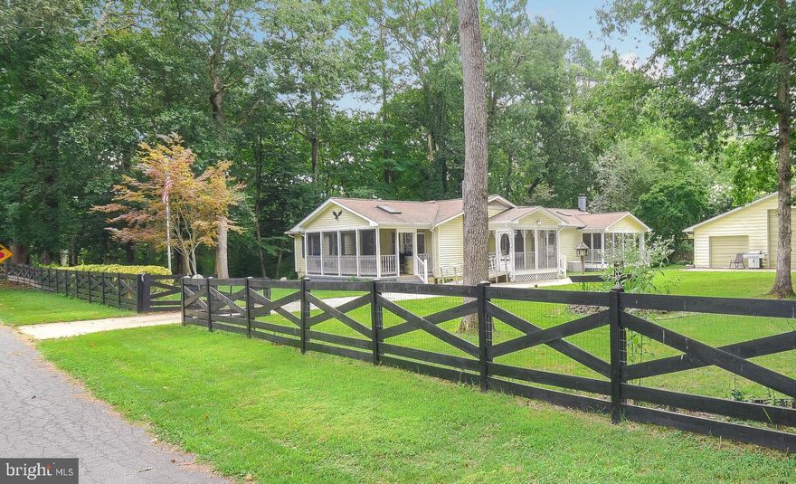 Located on almost 3/4 acres!  This 4 bedroom Ranch style modular home offers over 2,100 finished sqft;  providing plenty space for entertaining, hobbies, crafts, storage, etc.   Country Kitchen with nice view of level lot.  Living / Dining Room.  Family Room with wood burning stove.  Primary Bedroom with sitting room.  Spacious secondary bedrooms. Unfinished walk-up basement.   Three (3) screened-in porches provide comfortable spaces to relax and unwind.   Detached 3-bay garage, with HVAC, electricity, recently replaced roof, loft, parking and storage for your cars and toys. Generator and propane tanks convey.   Enjoy community beach access, trails and more.  Showings by appointment only.  Contact Agent for more information and to schedule your private showing.