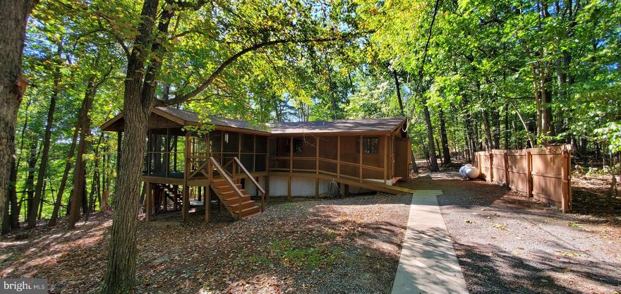 Very nice home with a beautiful setting in The Woods Resort / Walden Woods location.  Class A Indoor/Outdoor + Golf membership available with this home.  Home has some modifications for accessibility including ramp into the home via the large screened porch.  Great room features a wood fireplace and vaulted ceilings. This home has two full baths plus a half bath in one of the bedrooms.  Plenty of storage in the home and under the house is secure storage, plus crawl space.  There is a two car garage that is detached and plenty of parking plus sidewalk from garage to house.  The kitchen has a breakfast bar plus there is a large room just off the great room and kitchen that could be a very nice family/dining room area or home office, play room, etc.  Terrific views from every window.  Home needs some upgrades, there is no refrigerator.  Won't take much, though, to make it your perfect home or retreat.