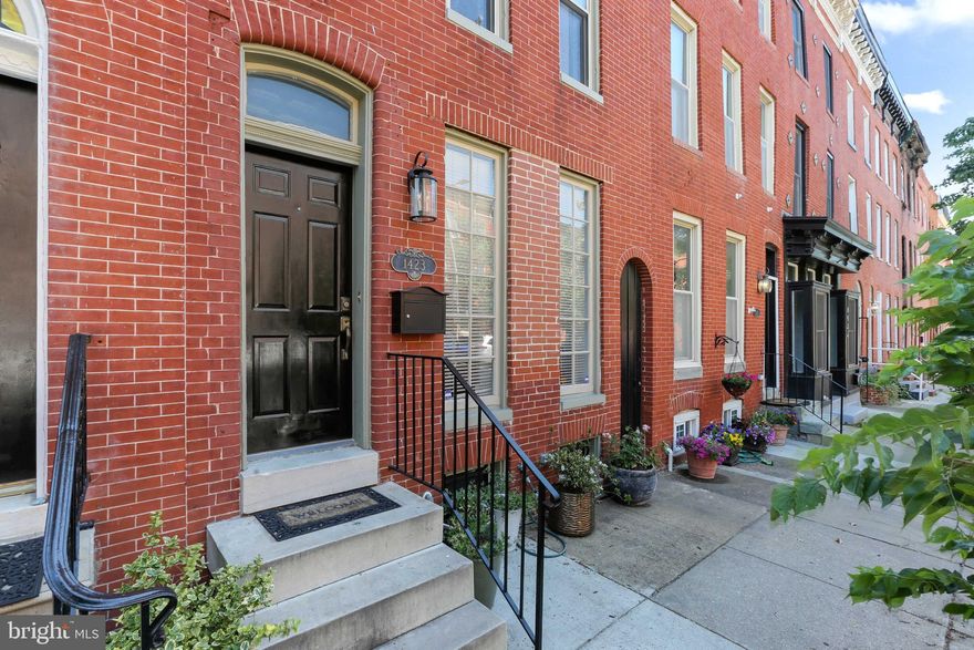 This grand Federal Hill property will exceed your expectations with tasteful updates that blend well with the meticulously maintained original details of this home, with the added convenience of GARAGE PARKING. Upon entering the 16 foot wide front of the home, youâll be greeted by hardwood floors, dentil crown molding, and original tin ceiling in the living room. The living room is long enough to have a TV area and separate sitting area near the fireplace, which is wrapped in marble and brass, and topped with a reclaimed wood mantel. This cozy space is perfect for reading and unwinding with a glass of wine. The dining room provides space for seating 6 or more, and the hardwood floors, shadow boxes, dentil crown molding, and chair rails add a sense of elegance that is sure to impress guests. The large kitchen features an excess of granite counterspace, including an island with a breakfast bar. Light is bountiful with 2 windows, recessed lights, and 2 pendant lights, which is reflected off the marble backsplash and the plentiful white kitchen cabinets. Off the rear of the home is a half bathroom and a mudroom. The rear yard and patio is shaded by a mature birch tree. This is one of the few properties in Federal Hill that affords you both garage parking and a rear outdoor space! The garage has power so an overhead garage door lift has been installed for added convenience. The space is perfect for one vehicle plus storage or a tight fit for 2 compact vehicles. Upstairs features a rear primary suite with 2 closets, wood ceiling, ensuite bathroom, and a private balcony overlooking the backyard. The wide hallway can be used as an office and exercise area. The hall bathroom and laundry room are located off the second floor hallway, just outside the large front bedroom. The 3rd floor features a massive bedroom with a vaulted ceiling, 2 closets, and an ensuite bathroom. The unfinished basement provides excellent storage. This home has so many upgrades: the roof replaced in 2021 (upper level resurfaced the same year), Dual zone HVAC units replaced in 2018 and 2020, hybrid water heater installed 2021, basement waterproofing 2022, fireplace installed in 2018, several new light fixtures installed since 2018, and many upgrades were made in the kitchen and bathrooms.