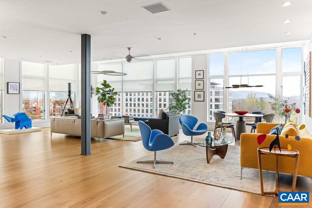 This stunning 2 BR, single-floor unit offers a light-filled living space with 26 floor-to-ceiling windows, providing panoramic views of the Blue Ridge Mountains, sunrise, and sunset. Custom designed by the owner, the home features hickory hardwood floors throughout and 2.5 luxurious bathrooms. The chef?s kitchen is equipped with Thermador appliances, including a dual-zone wine fridge, a pantry, and opens to a spacious great room. A private terrace is just steps from the kitchen. The primary bedroom suite offers a sitting area with sunset views, a custom walk-in closet, and a spa-like bathroom. The bath includes a large walk-in shower, free-standing soaking tub, and a smart Kohler toilet. The floating vanity has an uplift cabinet with hidden storage. The second bedroom is also spacious with a custom walk-in closet and a well-appointed adjoining bath with a large vanity and double sinks. The home includes a walk-in laundry room and additional storage in the foyer. This smart home allows for control of lights, shades, and appliances via Alexa or Siri. Solar film on all windows helps reduce heat gain/loss and block 99% of harmful UV light. One deeded parking spot with EV charging station included. All downtown amenities nearby.,Painted Cabinets,Quartz Counter