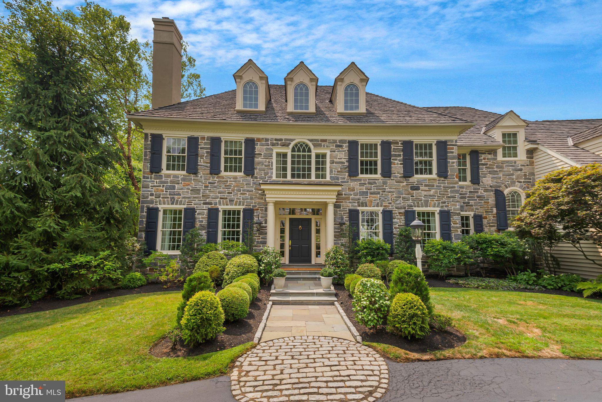 This elegant custom home by renowned Main Line Builder, Chip Vaughan, epitomizes gracious living in the sought after Brooke Farm neighborhood. The handsome stone front and custom covered entry are the first of many unique features you will notice in this exceptional property. An extensive front to back foyer has an elegant staircase and is flanked by a formal living room with gas fireplace and a formal dining room with stunning woodwork. A convenient wet bar is perfectly situated off the dining room and also has access to the kitchen and back staircase. The kitchen features a 12' island with seating for 5, tons of cabinet and counter space, walk in pantry, desk area and flows into the breakfast room. The sun-drenched breakfast room has great views of the backyard and a door to a new and spacious IPE deck with steps down to a flagstone patio. The family room has a coffered ceiling, gas fireplace and plenty of room for family gatherings. A handsome first floor office has gorgeous built ins that makes work from home a breeze. An oversized formal powder room with private hallway is useful when entertaining. A mud room with a back powder room and entrance to the 3-car attached garage complete this floor. The second floor offers 5 bedrooms and 4 full baths. The spa-like primary bedroom suite has a sitting room, his and hers walk in closets, 2 separate vanity areas and water closets and a newly renovated walk-in shower-you may never want to leave! The second bedroom has a walk-in closet and private bathroom. The 3rd and 4th bedroom have a Jack and Jill bath and walk in closets. The 5th bedroom is fabulous, offering an oversized bedroom and new custom marble bath. A cedar closet and laundry room round off the second floor. The back staircase continues to a huge 3rd floor attic that can be finished into additional living space if desired. The fully finished walk out basement offers more entertaining and living space. There is a large family room with French Doors to the backyard, beautiful wet bar, wine cellar, dedicated exercise room, game room/playroom, full bath and a huge storage room with an outside exit making it easy to bring your deck/patio furniture in and out. This space is also perfect as an au pair suite. The house is sited on a gorgeous lot adjacent to open space. This elegant home shows like a model home and has a generator, irrigation system, updated HVAC and more. The icing on the cake is the location in top-ranked Radnor School District, close to the charming village of Wayne offering lovely shops, restaurants, Aronimink and Overbrook Golf Clubs, and access to the R-5 train with quick access to Center City, and is convenient to major highways and Philadelphia International Airport.
