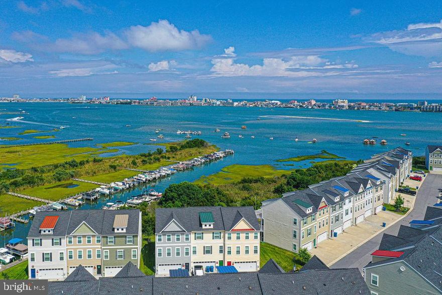 Direct bay front 4 b/r townhome with deeded boat slip in the heart of West OC is ready for you to view! This loved home is spotless, so well kept and conveys with three fully furnished & decorated floors to enjoy.  Energy efficient appliances and systems make for low utility costs. Some bonus features are Lennar... 42” custom cabinetry w/ complimentary granite, Stainless Steel appliances, engineered Hardwood flooring on main living level, custom blinds on all floors, ceramic tile in all 3 + 1/2 baths!  Lower level ideal for bedroom (check out the sweet Murphy bed disguised as a cabinet) with additional pullout couch. It could also serve as a second living area or game room/man cave w/ its own full bathroom, concrete patio & short walk to your dock. Large two car garage with two driveway spots as well as guest parking. Sensational bay and city views from multiple decks (larger decks in this floor plan) Seaside Village community has a Clubhouse with pool and a fitness center as well ashe best of OC shopping & restaurants at your fingertips! Find this listing on Zillow for your interactive 3D tour