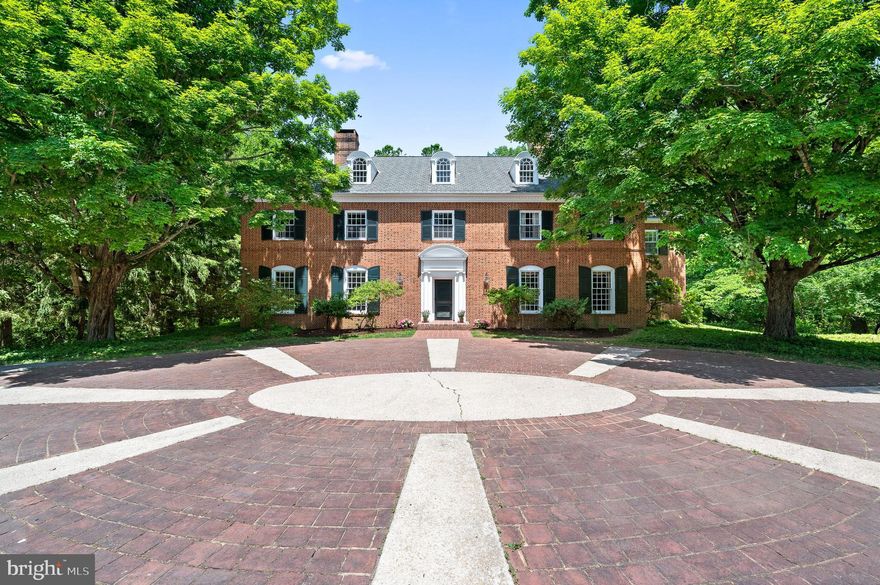Situated on over 50+ acres of rolling hills, meadows, woodlands, and a serene stream, this stately Brick Colonial offers a captivating blend of elegance, tranquility, and natural splendor. As you make your way down the long tree-lined lane, you'll be greeted by a circular brick courtyard entrance, setting the tone for the grandeur that awaits within. Step inside the 2-story foyer and be immediately captivated by the timeless charm of this home. The first floor boasts a formal living room and dining room, both adorned with 10 ft. high ceilings, wood-burning fireplaces, and custom crown molding, creating an atmosphere of refined sophistication. Adjacent to the dining room, a cozy library beckons with its built-in bookcases, a fireplace embellished with wood paneling, and access to a large wet bar, perfect for entertaining guests. Dutch doors seamlessly connect the living room, library, and family room, providing an open and welcoming ambiance. At the back of the house, a family room awaits, featuring a wood-burning fireplace, built-in bookcases, and French doors that lead to a brick terrace, offering a delightful space for outdoor relaxation and enjoying the picturesque surroundings. The generous-sized kitchen, located off the dining room, boasts a large window seat with panoramic views of the meadow and woodlands, creating an idyllic setting for culinary delights. Completing the first floor is a convenient mudroom with a powder room, tile floor, a dog wash area, and an additional back staircase that leads to the second floor. Ascend the elegant front staircase to discover the primary bedroom suite, occupying its own private wing. The primary suite boasts a wood-burning fireplace, a dressing area with double closets, and a spacious bath, providing a luxurious retreat. Four additional bedrooms, a Jack and Jill bathroom, and a hall bath offer ample space for family members or guests. Additionally, a large laundry room and a hallway of closets enhance the functionality of the second floor. For those with creative vision or seeking additional space, a stairway leads to the partially finished attic on the third floor. With high ceilings and five large windows allowing abundant natural light, this area is already roughed in for a full bathroom, presenting endless possibilities for customization and expansion. This remarkable property also features a substantial barn, offering versatility for horses, equipment, a studio, or the ultimate party barn—an ideal space for your imaginative pursuits. This offering includes two tax parcels. The house and 23+ acres and the adjoining 26+ acre parcel which offers even more potential, and the option for two potential residences. This presents an extraordinary opportunity for expansion. 1000 Hickory Hill is available for sale with 23+ acres, see MLS# PACT2046936. The 26+ acre parcel is only available with the sale of the 23+ acres and Manor home. Conveniently located with easy access to major routes, renowned restaurants, premier shopping destinations, and much more, this property provides a harmonious blend of tranquility and accessibility. Don't miss this incredible chance to own a piece of Chadds Ford's beauty and create a lifestyle that is both luxurious and captivating.