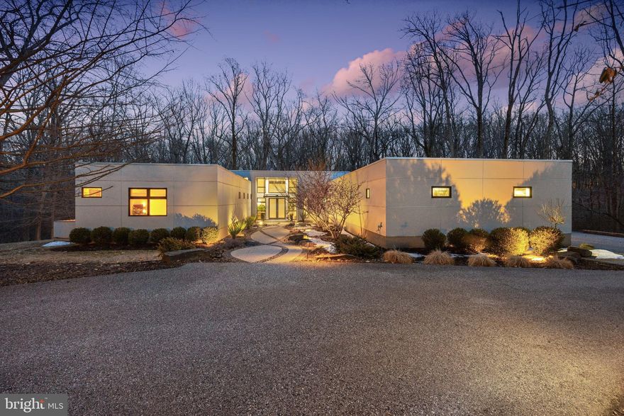 Welcome to this exquisite 2010 contemporary residence nestled on 2.5 private acres in the heart of Greenspring Valley. This stunning 4 bedroom,  5 and 1 half bath home designed by renowned architect, Chris Pfaeffle, offers peaceful tranquility with a focus on eco-friendly luxury. With 5219 square feet  of living space, the home is bathed in natural light thanks to the abundance of oversized windows, creating walls of glass which brings the outdoors in offering magnificent views of nature surrounding the property. High-end finishes and upgraded lighting throughout the entire house create a modern, elegant ambience.  The interior features natural materials like beautiful Teragren bamboo floors, custom bamboo kitchen cabinets, Loewen double pane windows and 8’ solid wood doors, and thoughtfully upgraded lighting, all on dimmers, make it easy to create ambience in every room. Ceilings of 10’ to 16’ add to the feel of openness and the windows at the top let even more light in. The fireplace and long cushioned window seat in the living room, create a warm feel, while the wall of built-in cabinets and bookshelves anchors the room. Be drawn to the incredible nature views outside thanks to the walls of glass and windows.  The light-filled kitchen is a culinary dream, featuring a suite of 2023 GE Café appliances, including 2 dishwashers, a French-door oven, a built-in microwave and electric induction cooktop with a venting drown-draft. An abundance of cabinet space, instant hot-water and island with extra seating make this an efficient and inviting area.  The primary suite is a serene retreat featuring a built-in king bed, large custom closet area, a long cushioned window seat and a private Ipe deck, perfect for listening to the sounds of nature and local bird life. The en suite bathroom with recycle glass countertops and high-end finishes is a perfect blend of luxury and sustainability. Each additional bedroom is nicely appointed and offers large windows with views and all of the bedrooms have full en suite bathrooms. The guest wing also includes its own private Ipe deck. The bathrooms are meticulously designed with Cherrywood accents and cabinetry, and state-of-the-art fixtures offering both functionality and elegance. Experience true indoor-outdoor living with a large Ipe and glass cantilever deck with seamless sight lines into the treetops and lush greenery. The outdoor kitchen features an imported Italian pizza oven and a new 2026 stainless steel gas grill, both plumbed for on-demand use, whenever the urge to grill and entertain strikes. Feel the allure of the saltwater HotSprings spa, which was added in 2021. Beautiful lighting, lines the exterior of the property, decks and driveway.