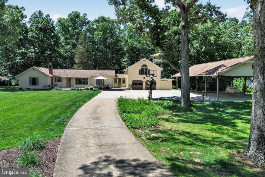 THE HOME<br> <br> 
At 3,724 square feet on 6.27 private acres, this five-bedroom, four-bathroom home strikes a balance that larger houses often miss — genuinely cozy, with rich wood floors, wood-trimmed windows, and rooms that invite you to settle in, yet spacious enough to live, work, and gather at any scale. It has been lovingly maintained within one family for multiple generations. Roof is architectural shingles (replaced in 2018) with gutter guards. Two cozy fireplaces. Double-paned Andersen windows. <br> <br>

A connected full suite functions equally well as an in-law apartment, a nanny quarters, or a private primary oasis — thoughtfully separated for independence while remaining part of the home. It has also been used as a full artist’s studio. It is the kind of addition that quietly transforms how you can live day to day. <br> <br>

THE OUTDOOR SPACE<br> <br> 
The grounds surrounding the home are lush and green with many opportunities for admiring flora and fauna. This home is nicely positioned on one of the paved roads in the community (deeper within the community the roads are gravel) with a paved driveway that winds amongst mature trees toward the home. The attached two-car garage currently serves as a fully equipped carpentry workshop, with flexible potential for vehicles, a studio, or storage. The pavilion carport can house an additional four cars. A separate outbuilding shelters lawn equipment. <br> <br>

The property has been designed — and deeply lived in — as an entertainer's destination. The grand pavilion anchors the outdoor space; large enough to host a wedding on site (which it has), it is equally suited to intimate summer dinners, crab boils, a concert on a crisp fall evening (curtains can quickly be pulled around to keep out wind or rain)— the kind of gathering space that becomes a family legend. It also includes a wind-down staircase and electronic lift with an extensive floored storage space in the eaves. <br> <br>

Multi-level decks wind through the tree canopy, anchored by a stamped concrete patio and custom tiki bar. A fantasy playground, woven into the wooded landscape, gives every generation a reason to stay outside. Walk into the additional acreage behind the house and play in the beautiful creek. <br> <br>

THE COMMUNITY<br> <br> 
The Moyaone Reserve is one of the most distinctive communities in the Washington metropolitan area — a 1,400-acre wooded enclave in Accokeek, Maryland, listed on the National Register of Historic Places just 10 miles south of the beltway. It sits within Piscataway Park, a 5,000-acre national park along the Potomac River, positioned directly across the water from George Washington's Mount Vernon. Federal scenic easements — established by Act of Congress and enforced by the National Park Service — protect every property here in perpetuity, preserving the rural landscape and the historic viewshed from Mount Vernon. This is not a developer's covenant. It is an agreement with the American people. <br> <br> 

The Moyaone Association is a voluntary community HOA, with a purpose that extends well beyond property values: to sustain the Reserve's rural character, historic identity, and local ecosystem. Residents enjoy a community pool, community pavilion, community garden, grill house, basketball court, playground, tiki refreshment hut, an active social calendar, and easy partnerships with neighboring institutions including the Alice Ferguson Foundation at Hard Bargain Farm, the Accokeek Foundation at the National Colonial Farm, and the Accokeek Artists Alliance. <br> <br>

The pace is slower here yet connected and vibrant. Enjoy every creative and nature-connected pursuit you can imagine — with good company. Commuting is easy to National Harbor, DC, Alexandria, Arlington, National Landing, Joint Base andrews, Joint Base Anacostia-Bolling.