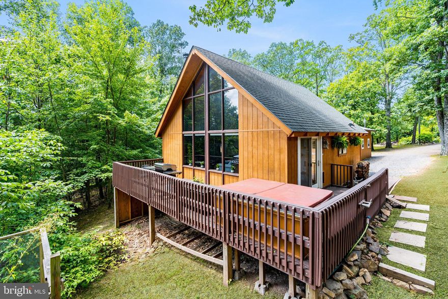 OFFER RECEIVED, BEST & FINAL BY MONDAY 9/29 AT 9AM.  THANK YOU!  This light-filled, chalet-inspired cabin blends modern updates with timeless mountain character, perfectly set in a quiet wooded setting.  The living room features wood plank ceilings, two-story windows, and a loft that overlooks the space. The open layout connects the living, dining, and kitchen areas, creating a comfortable and inviting atmosphere. The cabin is nestled in the woods of the Sleepy Hollow community, and includes access to a small private lake & beach.  Whether you're looking for a full-time home or weekend escape, this property is move-in ready and full of charm. Professionally designed with all new furniture, modern decor, hot tub, and a separate storage shed.  As a vacation rental it has generated $111,000 over the past 2 years, and can come with an existing property manager and cleaner. Hot tub and furniture optional, available for purchase.  See seller docs for a summary of rental history and financials.  $1,000 buyer credit if you continue using the same property manager.  Perfect full-time or vacation home!