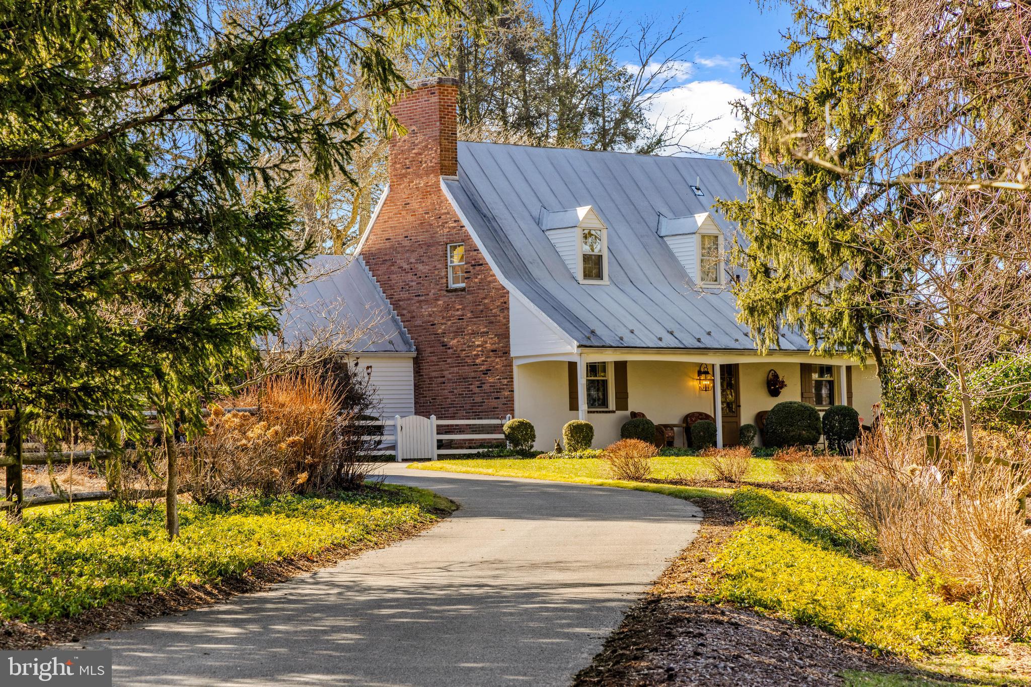 ***Request for offers by 2/16/24 at noon***Introducing 1009 Cloverlea Road, an exquisite Ruxton estate on just over an acre historically known as Rabbit Hill. The majestic acreage surrounds this carefully curated and lushly landscaped lot, offering perfectly level and private surroundings from all perspectives. A picturesque journey awaits along the long winding lane leading to this tidewater style home, adorned with touches of New England charm throughout. The brick porch front and standing seam roof exude timeless charm and elegance. Step inside to discover formal living and dining rooms retaining their original allure, complete with a wood-burning fireplace, wide plank wall trim, built-in shelves, nooks, and random width flooring. The bright main level primary suite boasts a full bath and ample closets for luxurious comfort. Experience culinary delights in the kitchen great room, featuring generous counter space ideal for cooking and baking, a cozy breakfast nook, and a welcoming family room. Recent sliders lead to the flagstone patio, offering stunning views of the sprawling yard—a perfect canvas for a future pool or pickle ball court and endless entertainment options. Completing the main level is a secondary bedroom suite with a full bath, a sitting area, and loft space, providing flexibility and convenience. Ascend to the upper level, where two additional charming bedrooms with window nooks await, along with a full bath, offering comfort and style. The finished lower level offers additional play space and ample storage, catering to every lifestyle need. Nestled atop a lovely point in Ruxton, this home boasts an ideal location just a stone's throw from Graul's Market and other coveted amenities.