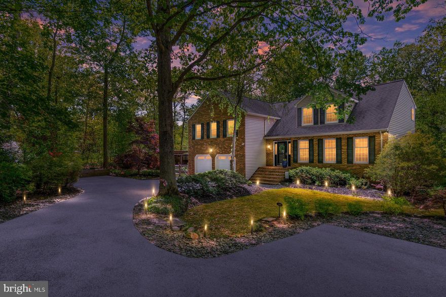 Tucked away in a private, wooded setting just minutes from Route 97, this beautifully maintained brick-front residence offers a rare combination of peaceful seclusion and everyday convenience—less than one mile to major commuter routes, yet completely hidden from view. A long, tree-lined driveway—framed by mature landscaping, flowering shrubs, and lush greenery—creates a serene, almost storybook approach, setting the tone for the home before you even arrive. Inside, the foyer opens to an expansive dining room filled with natural light, featuring hardwood floors, crown molding, and a large bright windows overlooking the picturesque front yard—an inviting space for both everyday living and hosting. The kitchen, fully renovated in 2020, is a true centerpiece of the home. Thoughtfully designed with both style and function in mind, it features an oversized center island with seating, two-tone cabinetry, quartz countertops, stainless steel appliances, a statement range hood, a Wolf induction cooktop, double ovens, and a beverage refrigerator, along with extensive custom storage throughout. Hardwood flooring continues seamlessly, and the space opens to a bright breakfast area with direct access to the deck—creating an effortless flow for gathering and entertaining. Just beyond, the spacious family room offers a warm and inviting retreat, complete with a wood-burning stove set within a striking stone surround and flanked by custom built-ins—adding both character and comfort. Upstairs, four bedrooms provide comfortable accommodations, including a thoughtfully designed primary suite that offers both space and flexibility. A separate entry area creates the perfect setting for a home office or sitting room, leading to the main bedroom retreat with hardwood floors, an additional sitting area, and two walk-in closets. The fully renovated primary bath is beautifully finished, featuring heated floors, a vaulted ceiling with skylight, a soaking tub, an oversized walk-in shower with detailed tilework, and a dual vanity—creating a spa-like space that feels both refined and relaxing. Three additional bedrooms are well-sized with great natural light and ample closet space, complemented by a well-maintained hall bath. The fully finished lower level expands the home’s versatility even further, offering a large recreation space ideal for entertaining, relaxing, or everyday living. A built-in wet bar/kitchenette with cabinetry, refrigerator, and microwave creates a natural gathering area, while additional spaces provide flexibility for hobbies, fitness, or play. A full bath and finished storage area add convenience, and sliding doors lead to a covered patio beneath the deck, creating a seamless indoor-outdoor connection. Outdoor living is another true highlight of this home. The expansive, multi-level low maintenance deck offers multiple areas for dining, lounging, and entertaining, all overlooking a private, tree-lined backyard. Below, the covered patio provides additional space to relax in any weather, while the level yard is surrounded by mature landscaping and seasonal blooms.  There is even a trailed pathway from the home leading to the Jabez Branch,  Severn Run's largest  tributary, where  trout, bass, and sunfish swim freely. A charming shed with electricity adds both function and flexibility. This home has been thoughtfully maintained and cared for over time, with quality updates including a newer HVAC system, offering peace of mind alongside its timeless appeal.  This is a home where thoughtful updates, beautiful finishes, and a truly private setting come together—just minutes from everything.