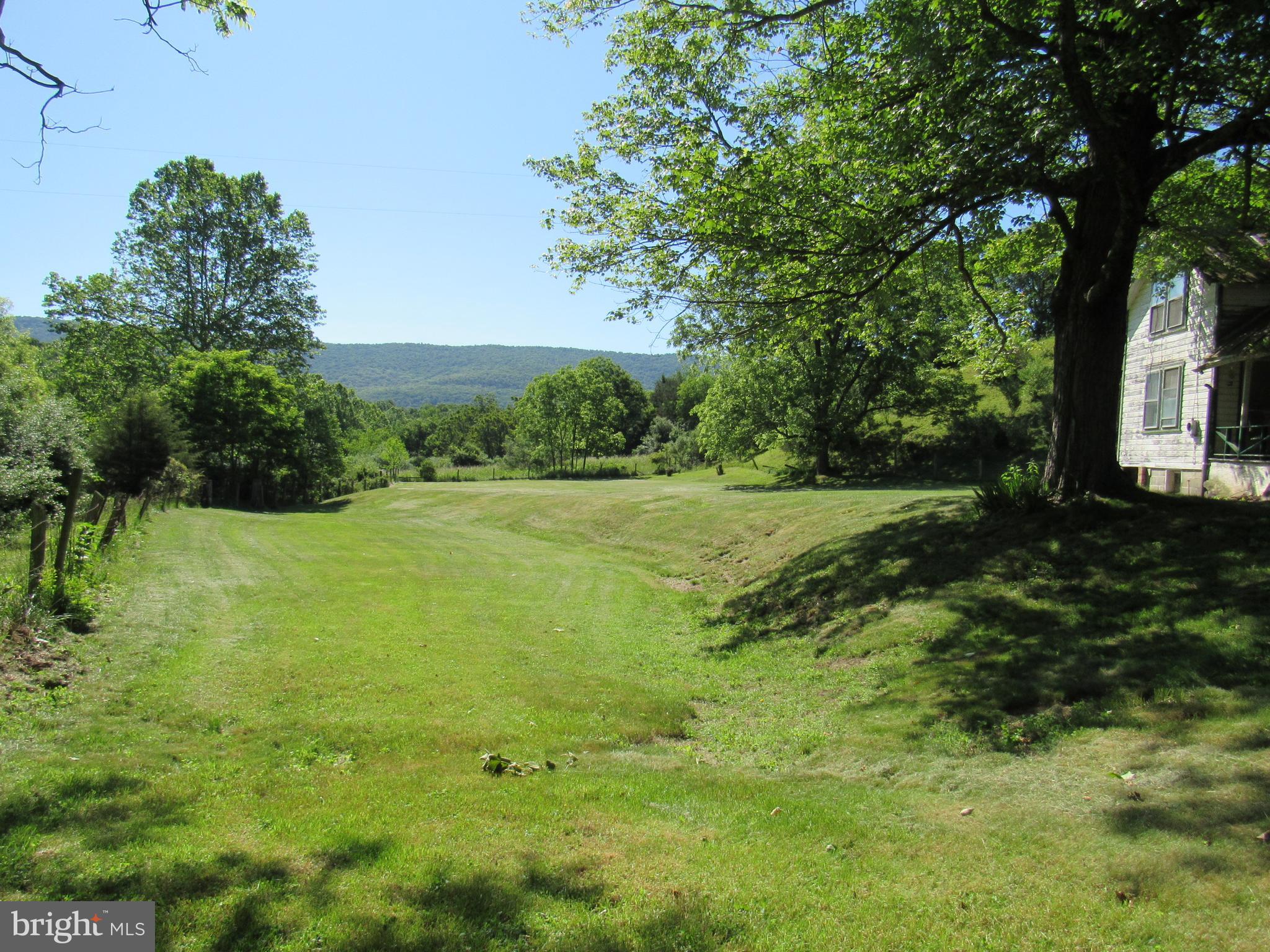 Tranquil and charming 6.5 acres with a small stream that adds to it's tranquility. Land is on a paved road just a few miles from Lost River StatePark, Kimsey's Run Dam and Trout Pond Recreation Area. This would be the perfect place to build your new home with lots of room left over for a big garden. There is a 1924 farmhouse on the property that hasn't been occupied for 40 years and is sold strictly "AS IS" House does not have well or septic. Please be aware that there is a nest of honeybees inside the kitchen walls and the bees are entering right above the door on the side porch. Please keep gates shut so cows don't get out.