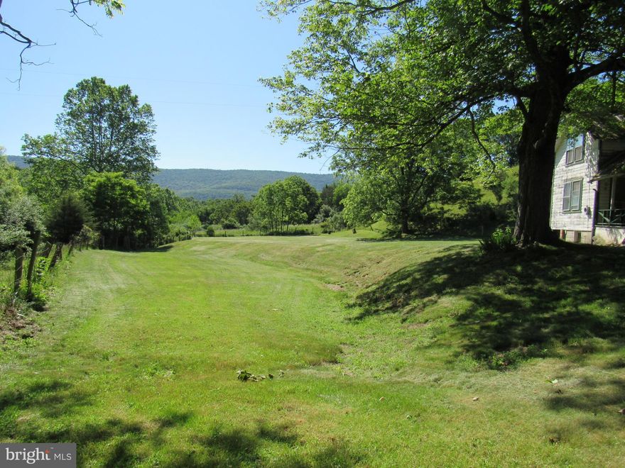 Tranquil and charming 6.5 acres with a small stream that adds to it's tranquility.  Land is on a  paved road just a few miles from Lost River StatePark, Kimsey's Run Dam and Trout Pond Recreation Area.  This would be the perfect place to build your new home with lots of room left over for a big garden.  There is a 1924 farmhouse on the property that hasn't been occupied for 40 years and is sold strictly "AS IS"  House does not have well or septic.   Please be aware that there is a nest of honeybees inside the kitchen walls and the bees are entering right above the door on the side porch.  Please keep gates shut so cows don't get out.