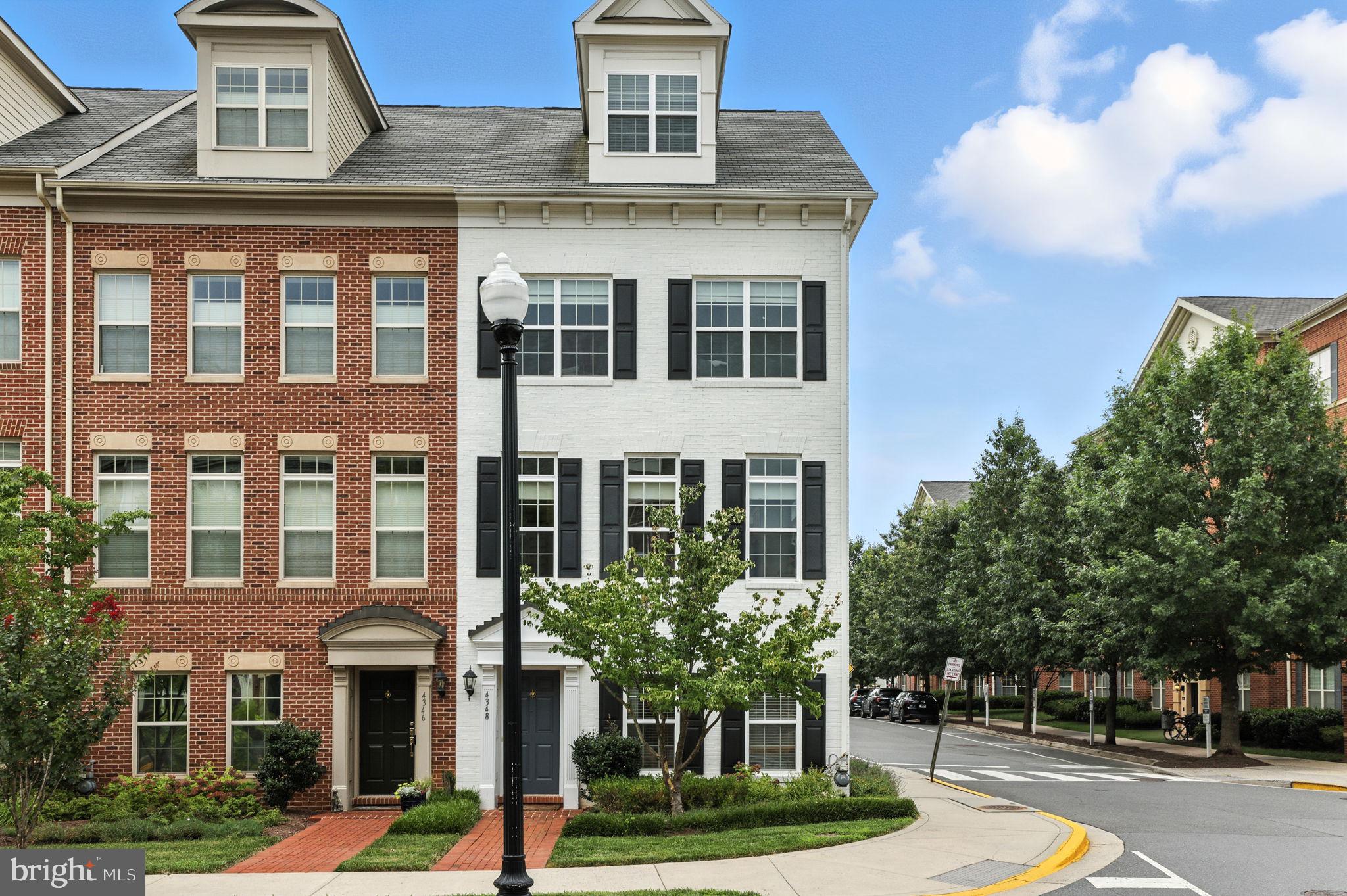 Welcome home to Ballston Row’s crown jewel! Perfectly positioned in the most desirable section of the community and surrounded by a tranquil park, this exceptional end-unit townhome offers four expansive levels of refined sophistication and elevated comfort. From its premier location to its meticulously designed interior, every detail of this residence reflects a seamless blend of modern elegance and luxurious living. Inside the entrance, a rare entry-level bedroom features French double doors and a private en suite bathroom offers the perfect setting for a quiet home office or guest retreat. Upstairs, rich hardwood floors flow throughout the expansive main level, where soaring floor-to-ceiling windows bathe the open-concept living space with natural light. The spacious gourmet kitchen impresses with bright Shaker-style cabinets, stainless steel appliances, sleek granite countertops and a classic subway tile backsplash. Entertain effortlessly at the oversized island, in the sun-drenched dining room, or unwind by the gas fireplace in the elegant living room, complete with custom built-in bookshelves. This airy and beautiful space is ideal for both everyday living and refined entertaining. Step outside to your private balcony to enjoy your morning coffee or a peaceful breath of fresh air. Upstairs, the primary bedroom suite exudes elegance with gleaming hardwood floors and a generous walk-in closet outfitted with a custom closet system. The elegant en suite bathroom offers an extra wide vanity and a luxurious oversized shower with a built-in seat and ceiling-mounted shower head. A second bedroom on this level also includes its own private bathroom and spacious closet, and the bedroom-level laundry adds everyday convenience. On the top level of the home, an expansive bonus room and third full bathroom offer incredible versatility for a fourth bedroom, home office, or in-law suite. Plush carpeting, a charming dormer ceiling, and access to a private rooftop deck elevate this space even further, making it a truly exceptional retreat. On the back of the home, the attached two-car garage provides abundant room for both parking and storage, and includes a built-in EV charger for your electric or hybrid vehicle. Ballston Row community amenities include ample visitor parking, a playground, and a tranquil green space at the heart of the neighborhood. Just minutes to Harris Teeter, Ballston Quarter, Lubber Run Park and Community Center, Virginia Hospital Center, Amazon HQ2, and The Pentagon. Less than one mile to the Ballston Metro Center, with quick access to Route 66, Glebe Road, Route 50, Columbia Pike, I-395 and I-495 for easy commuting. Blending luxurious design with unbeatable convenience, this exquisite home won’t be available for long! Schedule a private tour and make it yours today!