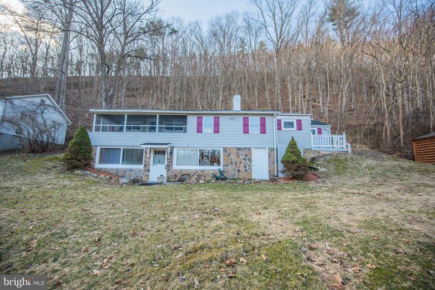 Property has two homes with a beautiful view of the water and frontage on The Cacapon River. The home to the left is two story with 3 bedrooms & partial river rock siding. Home on right is mobile with half log siding and two bedrooms.