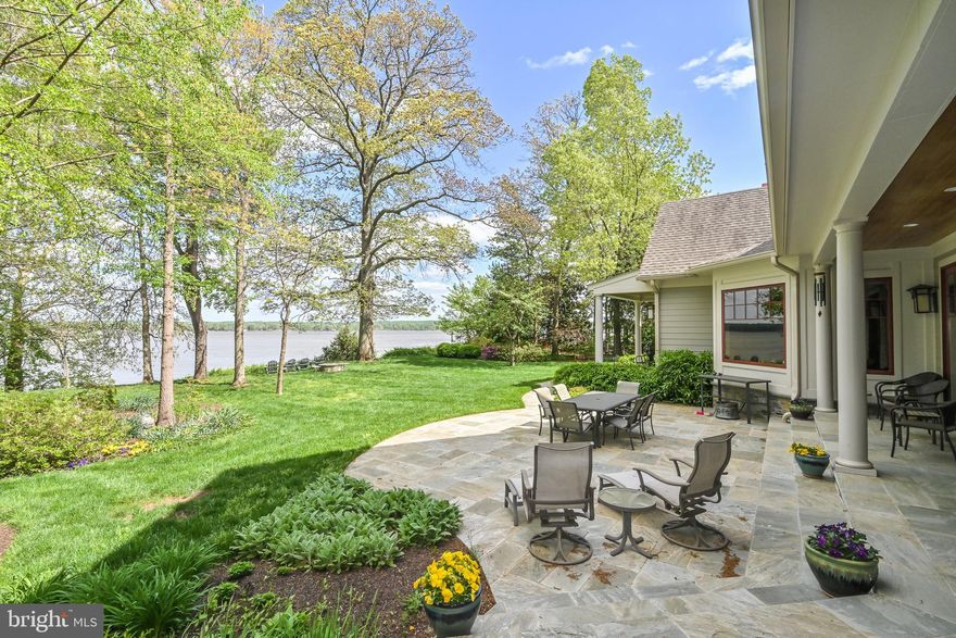 A Waterfront Masterpiece on The Potomac River, just 35 minutes from Washington, D.C., awaits in the enclave of Mason Neck—a sanctuary in Northern Virginia. Known for its expansive regional & state parks, pristine nature & wildlife reserves, equestrian facilities, and golf course, this area offers an unparalleled lifestyle of sophistication and serenity. Historically significant, the land was once the home of George Mason, a Founding Father and author of the Virginia Declaration of Rights, adding a rich cultural heritage to its allure. This distinguished estate boasts over 225 feet of breathtaking waterfrontage where you can drive down to a 269-foot private dock (no stairs), epitomizing an exclusive water-centric lifestyle. As you traverse the gated circular entry and immaculate grounds with beautiful native & ornamental plantings, you are greeted by the stately front motor court. Designed by the visionary architect Tom Flach and constructed by the renowned KohlMark Group, this craftsman-style residence showcases exquisite bespoke finishes throughout. Enter through an artisan-carved stained glass door into the grand foyer, where a majestic barrel vault ceiling with cedar wood inlay and elegant cove lighting adorns the travertine center hall. Panoramic water views grace every space on the main level. The formal living room features a coffered ceiling, an opulent marble-surround wood-burning fireplace, and custom built-ins. The adjacent formal dining room, also with a coffered ceiling and intricate crown moldings, opens to luxurious outdoor entertaining spaces with breathtaking river views. The gourmet kitchen, clad with richly painted cherry cabinetry, lustrous quartzite countertops, and an expansive island, boasts professional-grade stainless steel appliances. A rear pantry with commercial-grade appliances, a main level laundry, and rear staircase complement the kitchen. The breakfast area opens to the hearth/ family room, featuring a striking cedar cathedral ceiling, a grand stone fireplace, custom built-ins, and sweeping water views. In the left wing, an octagonal library opens to the rear patio. An elegant office or optional bedroom with a full bath and walk-in closet, along with a refined study featuring a wet bar, opens to a private screened-in porch. Ascend the staircase, adorned with a stunning blue heron stained glass window, or take the private elevator to the upper level. Double solid wood doors open to the sophisticated primary suite sitting room with a marble gas fireplace and captivating water views. The primary bedroom features another stunning cedar cathedral ceiling and a bowed bay window. The spa primary bath, with split vanities, luxurious marble finishes, and an oversized shower, has a second entry from the wardrobe hall lined with built-ins leading to two expansive walk-in closets. The upper front hall, with custom built-in benches, leads to secondary bedrooms, each with en-suite baths showcasing designer finishes. Beyond the upper-level laundry room and powder room lies an engaging game room or optional fifth bedroom. On upper level 2, a fully unfinished space offers boundless potential for future expansion. The lower level features an expansive exercise room, full bath, and a walk-out level recreation room. With over 2,300 square feet of unfinished space, there is ample opportunity for additional customization. The meticulously landscaped rear grounds include a grand stone patio, ambient landscape lighting, an inviting fire pit, and commanding views of the majestic Potomac River. The community features a waterfront park with a beach, pavilion, boat launch, tennis, volleyball, and basketball. This exquisite location is near Old Town Alexandria, Fort Belvoir, & VRE Station, and has easy access to I-95 enhancing this retreat's appeal. This haven is a paradise for nature enthusiasts & boating aficionados alike, embodying unparalleled sophistication, elegance, & refined living—a true waterfront masterpiece.