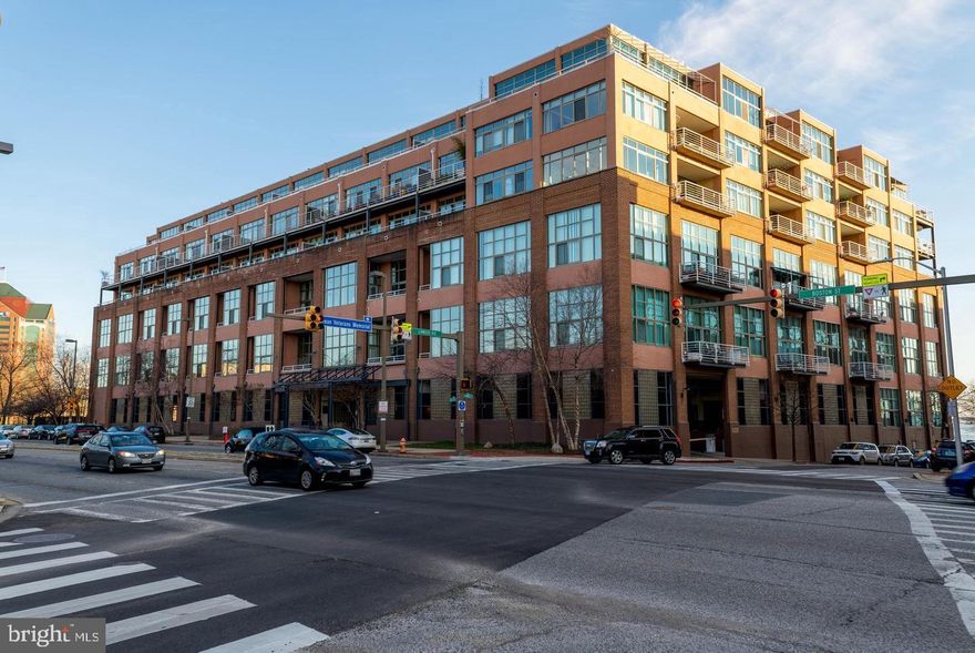BIG loft style two story Condo @ 2883 square feet! Amazing soaring ceilings and a huge wall of glass in the Living Room with access to the ample balcony! Dining Room open to the Living Room and Kitchen. Great open spaces! Like to cook? The Kitchen is made for a party! Beautiful granite counters, stainless steel appliances and tons of counter and cabinet space. Additional eating space for casual dining off the Kitchen. If you like to cook you will love the adjoining pantry/Laundry Room  has tons of storage. To round off the main floor there is a totally fun built in bar. Where is Don Drapper? Set apart half bath for guests. 1st Floor Primary Bedroom boasts soaring ceilings, marble flooring with yet another huge set of window. Updated Primary Bath contains a shower and separate tub. Plus two ample closets. Yup, TWO. Head upstairs to the 2nd level and you will find 2 additional loft Bedrooms  and a den that could be used as a home office. No need to worry about parking the unit comes with its own parking space.  You will LOVE the building staff. They are wonderful. The roof top deck will leave you stunned! It has THE BEST views.  The views stretch forever and look directly at Fort McHenry! Wait until you  see the fireworks. Looking for a fab place to call your own?  Bored with out of the box condos? Come check out unit 220!