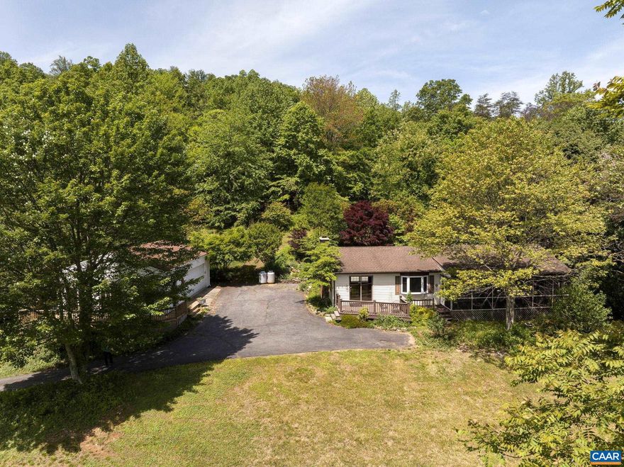 Escape to your mountain oasis just 30 minutes to Charlottesville!� This comfortable 3 bedroom 1,1/2 bath ranch style home with a large dining, living and bonus room� tucks perfectly into the spectacular� property.� It will be hard to pick a favorite place to enjoy your private retreat. The screened porch on the front is perfect�for catching summer rain storms. The massive stone patio on the back is nestled into the hillside with a beautiful�koi pond and carefully curated gardens designed to delight all year round!� The large detached garage and finished studio space boast spacious decks and a secret garden space.� Additional�storage is provided by a sturdy carport and a large shed. Enjoy the seclusion this property provides with�the option to stay connected or work from home with high speed internet!� Located just minutes to Maybell's Market, Blue Ridge School as well as a few local vineyards.