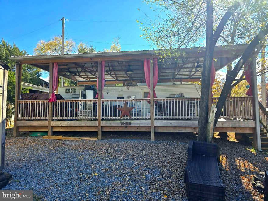 This exceptional large corner lot features convenient access to sewer services, making it a prime choice for your outdoor adventures. Included with the property is a spacious 36-foot 2006 Nomad travel trailer, perfect for all your getaway needs. The trailer boasts an outdoor kitchen equipped with a refrigerator, ideal for cooking and entertaining alfresco. 

You’ll also find a charming deck complete with a table and chairs, perfect for enjoying morning coffee or evening gatherings. For added comfort and enjoyment, there's a lovely pavilion that offers shade and a relaxing atmosphere.

Located just a short distance from fantastic amenities, this lot is near the community pool, camp store, and a fun putt-putt golf course. Don’t miss the opportunity to schedule a showing today and explore all the potential this property has to offer!

This is a gated community, so you need to enter at the guard shack. Entry is not permitted without ID per the office rules. Bring IDs to the office or guard shack for visitor pass. THIS IS A SEASONAL CAMPGROUND! OPEN FROM APRIL 1 TO NOVEMBER 1. This lot is conveniently located for walking to the swimming pools, restaurant/lounge, mini golf, youth center, playgrounds and more. Large lot to enjoy time with your family & friends. River Bend is a privately owned 400 acre recreational- vehicle camp resort with seasonal activities for members, families and guests. Less than a 2-hour drive from the Washington and Baltimore metro area. Open with utilities from April 1 to November 1. Lot owners have access to their property the entire year. *** Members Enjoy *** * Amazing views and wildlife, Potomac River access, Trails, Swimming pools, Mini-Golf, Youth center, Tennis and basketball courts, laundry facilities, convenience store, deli and lounge. *Bath houses throughout the park, boat ramp, bar and grill and even a church located on the grounds. River Bend also hosts numerous activities such as 4th of July fireworks, small carnival, bonfires, poker runs, horseshoe tournaments, car show, Halloween Trick or Treat and so much more. The river is deep water for swimming, tubing, and water skiing. CAN NOT LIVE HERE YEAR-ROUND