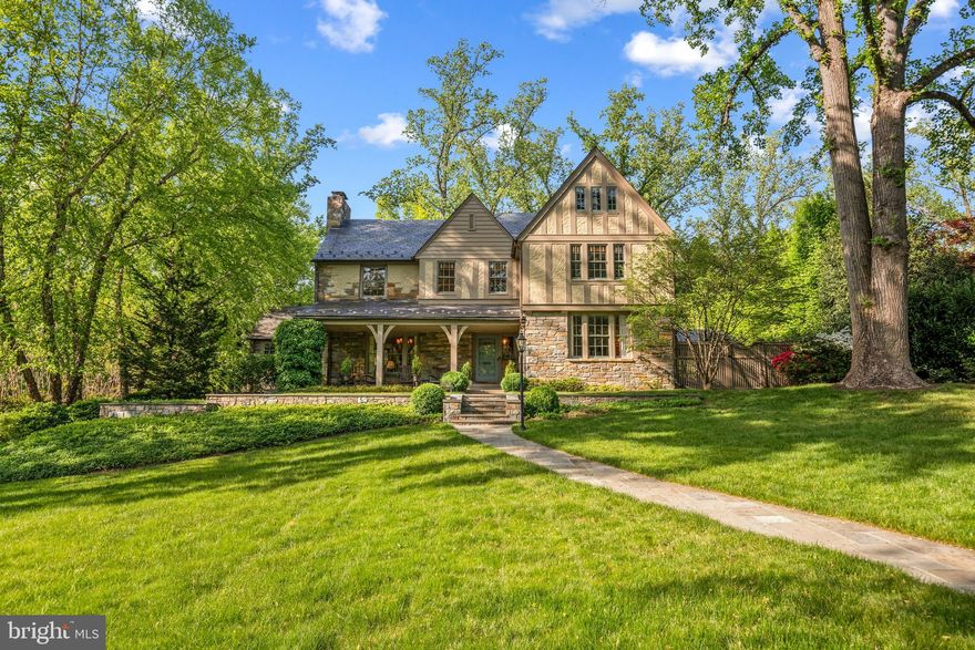 Elegantly appointed on one of the most coveted streets in all of Northwest DC sits 4907 Indian Lane. Built in the 1920s, this stately Tudor-style residence is revered as one of the oldest homes in Spring Valley. Only three owners to date, this is truly a rare opportunity with unparalleled privacy in the heart of the Nation’s capital. The expansive .63-acre lot offers timeless charm and exquisite architectural details, reflecting the era’s true craftsmanship.

Inside, over 5,000 square feet of finished living space includes gracious entertaining rooms and an abundance of natural light. Seven bedrooms and four and a half bathrooms spread across four levels of luxurious living.

Off of the covered front porch, the main level features an inviting entrance foyer, a living room with a wood-burning fireplace, a sun room with a wood-burning fireplace, a formal dining room, a chef’s gourmet kitchen, a breakfast / family room with a wood-burning fireplace, a screened porch with a wood-burning fireplace as well as a powder room, coat closet, and access to the oversized garage. The renovated kitchen was thoughtful in design with an abundance of counter space and storage, top-of-the-line appliances, custom cabinetry, two sinks, and gorgeous soap-stone counter tops.

Upstairs to the second level, the private quarters feature a spacious primary bedroom suite with a walk-in closet and renovated primary bathroom with a vanity area. Completing this level are three additional large bedrooms, a renovated hallway bathroom, a hallway linen closet, and an upstairs library / recreation room with a vaulted ceiling. On the third level, there are three more bedrooms, a renovated hallway bathroom and a cedar closet. The lower level has a 1,000 bottle wine cellar, a steam shower with an additional renovated full bathroom, a laundry area, and a storage / utility room.

The beautifully manicured property grounds include mature trees, spectacular landscaping, an intimate side garden, multiple dining and lounging areas, a covered barbeque station, and an enviable 20 x 40 foot long swimming pool. An attached oversized garage, motor court, and long private driveway add to this sprawling estate.

Embodying the epitome of grand scale living in one of the city’s most desirable neighborhoods, 4907 Indian Lane, NW is a rare opportunity new to the market.