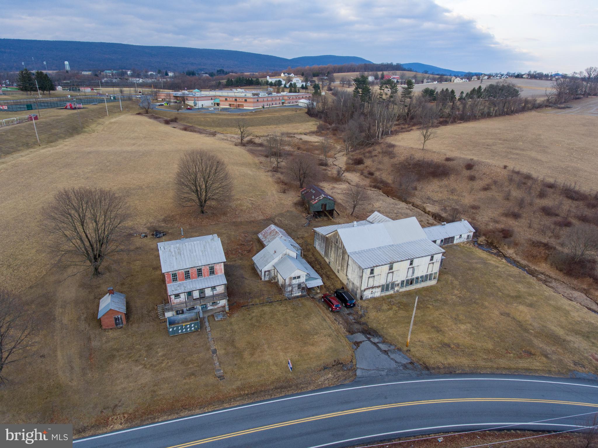This property is being offered for sale at auction on Thursday, April 17, 2025 at 3:00 PM. List price is the suggested opening bid only and is not indicative of the final sale price. Open House: Saturday, March 29, April 5 & 12 (1-3 pm.) or by appt. Terms: 10% down day of sale; settlement within 45 days of sale.
REAL ESTATE: 32.88 ACRE FARM w/3 sty. brick farmhouse containing approx. 2,400 SF of living area. Ground level includes an eat in kitchen/living room and utility room. Main level has a foyer, 3 bedrooms and a full bath. Third level includes another kitchen, 4 bedrooms, and a full bath. The home has a full attic, 9’ ceilings, a covered front porch, coal fired hot air furnace and on site well and septic. OUTBUILDINGS: 62 x 60 stone & frame bank barn w/addition & attached 21 x 80 chicken house; 23 x 30 two-story former milkhouse w/water & electric & attached 34 x 20 garage; 10 x 15 brick smokehouse. LAND: Approximately 24 acres of tillable land with approx. 1935’ road frontage.
28.07 ACRES OPEN LAND in Windsor Township and Hamburg Boro with approx. 20 acres tillable ground and 1,300’ road frontage, zoned Ag and Medium Density Residential, with subdivision possibilities. Sold separately from farm.
NOTE: This quiet and peaceful farm has been in the Merkel family since the mid 1800’s and this is the first opportunity for purchase. The farm offers plenty of opportunity, zoned agricultural, bordering Hamburg Boro and within minutes of downtown Hamburg with easy access to Rts. 61, 78 and Old Rt. 22. This farm and land is in Clean and Green but not in Ag Preservation. The buildings are in need of repair, offering opportunity for renovations.