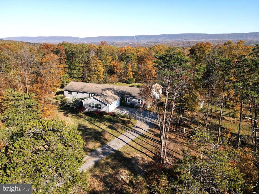 If looking for peace and calm amidst the soothing sounds of nature, this unique home may inspire you!
Less than a mile from Route 522, nestled between Cacapon and Sleepy Creek Mountains, in a forest on a hill , this quiet villa  features living room, great room, two kitchens, 4 bedrooms, den that is currently used as a bedroom (no closet) and 4 1/2 baths. Property can be utilized as one large home or as two separate and complete living quarters for guests, family, etc.
Accessibility features/finishes would also make it ideal for multi-generational households.
The 2 car attached  garage  has separate entrances, HVAC systems, total of four decks, 2 Mendota gas fireplaces, additional electric bb in 2 rooms, Kohler back up generator. 
Outside there's a matching shed w/ porch and electric.
Large, level  backyard is complete with double fencing, gardens w/ fruit producing trees & bushes.
Centrally located between Cacapon State Park with all its amenities such as biking, hiking trail, world class golf course, horseback riding and more, and five miles south of the day to day necessities, grocery store, medical offices, banks, and, of course dining and shopping. You will fall in love with the area and the charming Town of Bath/Berkeley Springs known for its historic significance, natural springs, and a vibrant arts community.