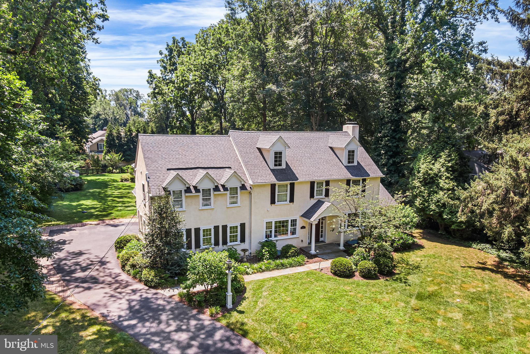 Located on a picturesque tree-lined street in one of the Main Line’s most desirable neighborhoods, this stunning Colonial offers the perfect blend of timeless charm and modern comfort. Featuring 5 bedrooms, 3 full and 2 half bathrooms, and a beautifully landscaped, flat rear yard oasis, this home is a rare opportunity in a highly walkable area just minutes from top-rated schools, train access, shopping, and dining. Step through the front portico and into a thoughtfully upgraded interior with gleaming hardwood floors, elegant millwork, and abundant natural light. The main level boasts a spacious formal dining room with French doors that open to the rear yard and access to a bright sunroom with tile flooring that offers year-round enjoyment. The expansive gourmet kitchen is a chef’s dream with granite counters, a large center island, breakfast area, stainless steel fridge, wet bar, and gas cooking. The adjacent family room features a slate surround gas fireplace and custom built-in cabinetry. A private office/study with glass doors and deep windowsills, powder room, and mudroom with access to the 2-car garage complete the first floor.
Upstairs, you'll find hardwood flooring throughout, charming window nooks, and a luxurious primary suite with vaulted ceiling, two walk-in closets, and a spa-like bath with double marble vanity, seamless glass shower, and soaking tub. Bedroom 2 features an ensuite bathroom, while bedrooms 3, 4 and 5 share a full large hall bathroom. A second-floor laundry room with sink and storage adds convenience. The walk-up third-floor attic is fully floored and ideal for storage. The finished lower level includes a second half bathroom, a large recreation/media room, gym, and additional storage with walk-out access to the side yard. Outside, the private backyard retreat features a flagstone patio, perennial gardens, and mature landscaping—perfect for entertaining.
Additional highlights include: First-time on the open market in over 50+ years, completely rebuilt approximately 15 years ago, backup gas generator for peace of mind. This move-in-ready home offers character, quality craftsmanship, and a location that’s second to none. Don’t miss the opportunity to own a truly special property on the Main Line.