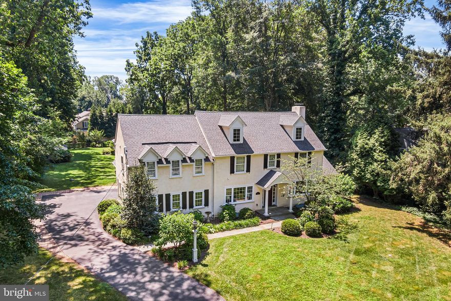 Located on a picturesque tree-lined street in one of the Main Line’s most desirable neighborhoods, this stunning Colonial offers the perfect blend of timeless charm and modern comfort. Featuring 5 bedrooms, 3 full and 2 half bathrooms, and a beautifully landscaped, flat rear yard oasis, this home is a rare opportunity in a highly walkable area just minutes from top-rated schools, train access, shopping, and dining. Step through the front portico and into a thoughtfully upgraded interior with gleaming hardwood floors, elegant millwork, and abundant natural light. The main level boasts a spacious formal dining room with French doors that open to the rear yard and access to a bright sunroom with tile flooring that offers year-round enjoyment.  The expansive gourmet kitchen is a chef’s dream with granite counters, a large center island, breakfast area, stainless steel fridge, wet bar, and gas cooking. The adjacent family room features a slate surround gas fireplace and custom built-in cabinetry. A private office/study with glass doors and deep windowsills, powder room, and mudroom with access to the 2-car garage complete the first floor.
Upstairs, you'll find hardwood flooring throughout, charming window nooks, and a luxurious primary suite with vaulted ceiling, two walk-in closets, and a spa-like bath with double marble vanity, seamless glass shower, and soaking tub. Bedroom 2 features an ensuite bathroom, while bedrooms 3, 4 and 5 share a full large hall bathroom. A second-floor laundry room with sink and storage adds convenience. The walk-up third-floor attic is fully floored and ideal for storage.  The finished lower level includes a second half bathroom, a large recreation/media room, gym, and additional storage with walk-out access to the side yard. Outside, the private backyard retreat features a flagstone patio, perennial gardens, and mature landscaping—perfect for entertaining.
Additional highlights include: First-time on the open market in over 50+ years, completely rebuilt approximately 15 years ago, backup gas generator for peace of mind. This move-in-ready home offers character, quality craftsmanship, and a location that’s second to none. Don’t miss the opportunity to own a truly special property on the Main Line.