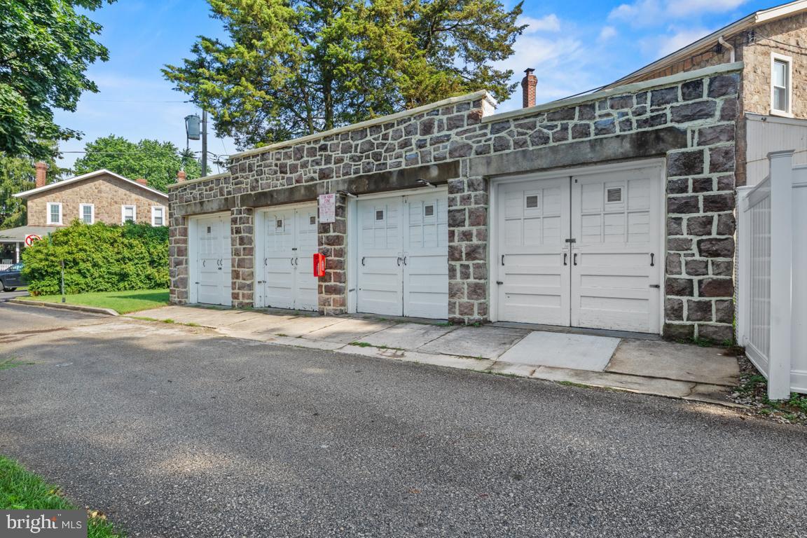 Unlock the potential of this versatile 4-bay garage located in Ambler, PA. Situated on a quiet, tucked-away street just minutes from major routes, this standalone commercial property offers endless possibilities—ideal for business owners, contractors, mechanics, or investors seeking secure storage or a functional workspace. The building features four oversized garage bays with high ceilings, perfect for vehicle storage, equipment, tools, or operating a small business. It also has a newer roof and it was recently repointed. The unit was brought up to code with the fire extinguisher and patched sidewalk. Each unit has its own electricity and water that can be controlled individually. Whether you’re looking to launch an auto repair shop, detailing business, landscaping operation, or simply need a centralized storage hub, this property delivers flexibility and convenience. Highlights include- Private, off-street location, Ample parking, the yard next to the garage, Concrete floors and durable construction, Easily accessible from Route 309, PA Turnpike, and surrounding commercial corridors. This is a rare opportunity in Ambler to own affordable, standalone space with room to grow.