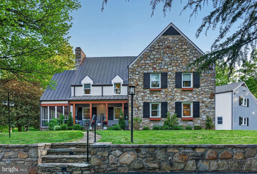 Rarely does a property of such quiet distinction come to market. Spanning more than 36 acres across three combined lots and backing to protected land, this remarkable estate offers a rare sense of seclusion—just minutes from the heart of Haymarket.

The five-bedroom farmhouse is a thoughtful blend of historic charm and modern refinement. Sunlight fills the interiors, where exposed wood beams add warmth and character. The chef’s kitchen, appointed with soapstone countertops and a professional-grade gas range, is equally suited for intimate gatherings or larger-scale entertaining. A stunning wraparound porch—partially enclosed and anchored by a fireplace—extends the living space outdoors, overlooking sweeping lawns, mature trees, and a serene pool and spa set against the backdrop of the Bull Run Mountains.

Every detail has been carefully considered. Recent enhancements include wide-plank flooring throughout, a reimagined primary suite, updated secondary baths, and a refined laundry and mudroom. Significant exterior and systems upgrades include a new copper roof, gutters and downspouts, cedar siding, a paved driveway, hand-laid stone walls, a new gas furnace, hot water heater, and a comprehensive security system. The three-car garage, complete with a dedicated workshop, offers exceptional utility for collectors or hobbyists.

A private office suite—with its own full bath, secure access, and high-speed connectivity—provides an ideal setting for remote work or creative pursuits. With a separate rear stairway, it also offers flexibility as an au pair or in-law suite.

The grounds are equally extraordinary. Private walking trails wind through wooded areas rich with wildlife, while a spring-fed pond reflects the changing seasons. A charming working homestead, complete with duck and chicken coops, adds to the property’s authentic country appeal. Multiple terraces, both covered and open-air, along with fireside gathering spaces and expansive lawn areas, create an ideal setting for year-round enjoyment.

This is more than a home—it is a legacy property defined by land, light, and enduring beauty. The county has reportedly granted preliminary approval for additional building rights and potential family subdivision across the three lots, offering long-term flexibility. A portion of the property is also protected by a conservation easement, preserving its natural character for generations to come. Buyers are encouraged to independently verify all details related to development rights, subdivision potential, and easement terms.

For those who value privacy, scale, and timeless setting, this is a truly rare offering.