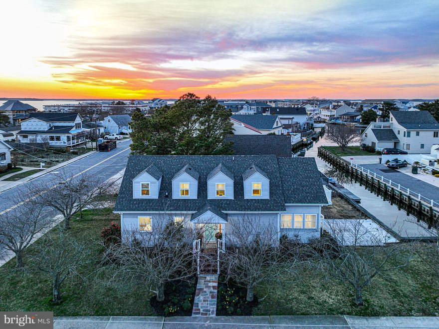 Under Contract - Open House cancelled. Walk to the beach, then hop in the bay - the best of both worlds! Your own private canal-front oasis in Ocean City, fully furnished and completely renovated over the last year from top to bottom, inside & out, with no detail spared. This corner lot coastal dream home provides up to six bedrooms and three full baths, with tons of flexible space. The main level provides an open floor plan with plenty of room for everyone and so much natural light - a gourmet kitchen with large center island and ample seating, pendant lighting, quartz counters, tile backsplash, stainless appliances, separate wine fridge, and a large pantry. The kitchen seamlessly blends with the family room, which offers an electric fireplace with accent tile, a reclaimed wood mantel, built-ins, open shelving with uplighting, and custom wood paneling. Enjoy a second sitting area adjacent to the kitchen, as well as a dining area with a table large enough for eight or more. Step out of the sliding glass door to the brand new stone patio where you can barbecue and enjoy summer evenings, then hop in your kayak, paddle board, or into your personal watercraft and zip right out into the bay. Back inside, the main level of the home provides a convenient laundry room with brand new Samsung washer & dryer, three bedrooms- all with large closets, and a full bath with dual sinks. On both levels of the home, you will find low maintenance Coretec luxury vinyl plank flooring, recessed lighting, new light fixtures, custom tile, accent moldings, and fresh, neutral paint. At the top of the stairs on the upper level, you will find a second family room, which can also be used as an oversized bedroom, a home gym, game room, playroom, or anything else that fits your lifestyle. Upstairs you will also find a home office which could be utilized as a bedroom as well. You'll also find a full bath with dual sinks and an extra deep linen closet. Down the hall, revel in the owner's suite with a sitting area, a large walk-in closet, sliding glass doors to a Juliet balcony, two additional closets for storage, and a stunning spa bath with soaking tub, separate shower, accent wall tile and a barn door. Yet another bonus space on the upper level is a large, converted attic, providing even more space for extra storage or even a fun play area. Rest assured knowing that nearly every single aspect of this home has been replaced in the last year: windows, doors, a fully encapsulated crawl space with dehumidifier and sump pump, new zoned HVAC, new hot water heater, plumbing, electric panel, appliances, new railings, new stonework, new side stone patio, new decking, roof (2022) & gutters, professional landscaping, an EV charger, and brand new furniture & furnishings. This home has never been a rental, but would make an exceptional and lucrative investment property- just check out Airbnb for comparable rentals! No HOA. Walk just around the corner to Liquid Assets, Bull on the Beach, or Candy Kitchen. The best of OCMD! Don't miss this one.