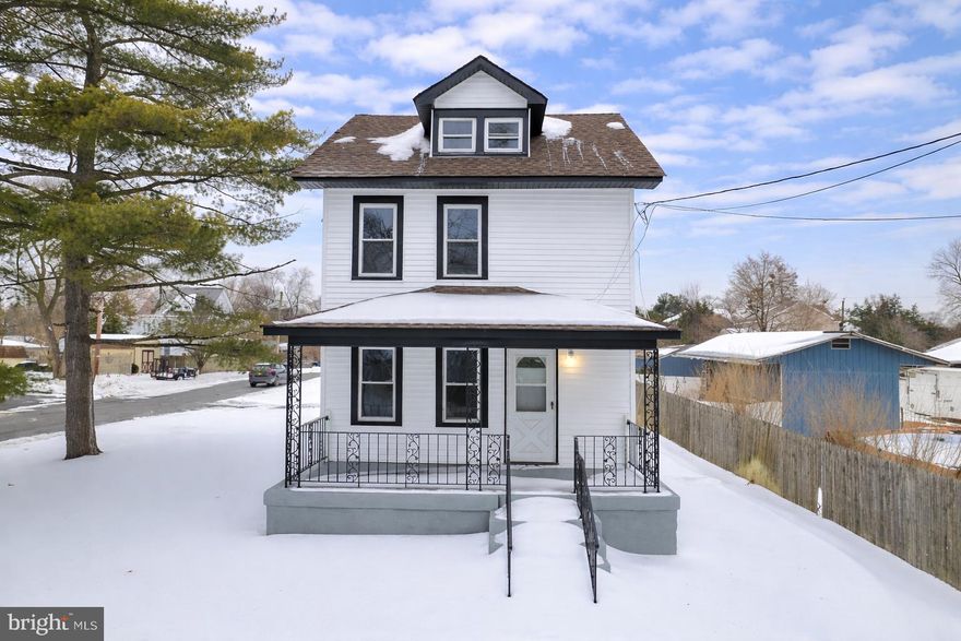 Charming two-story home showcasing 4 bedrooms and 2 full bathrooms with a classic curb appeal, featuring crisp white siding and contrasting black trim.   A covered front porch with decorative iron railings welcomes you in, offering a cozy spot to relax.  Inside, the home has been tastefully updated with a bright, modern interior.  The kitchen showcases white shaker-style cabinetry, granite countertops, stainless steel appliances, and a sleek gooseneck faucet all complemented by durable tile flooring and recessed lighting.   The kitchen flows seamlessly into the living area, creating an open, inviting layout ideal for everyday living and entertaining.   Large windows throughout provide excellent natural light, while neutral finishes offer a clean, move-in-ready feel.  A finished dormer adds character and additional upper-level space.  Situated on a spacious lot with a fenced backyard , this homes offers privacy, comfort, and convenience on a quiet street close to local amenities.   Don't miss out on this great opportunity.