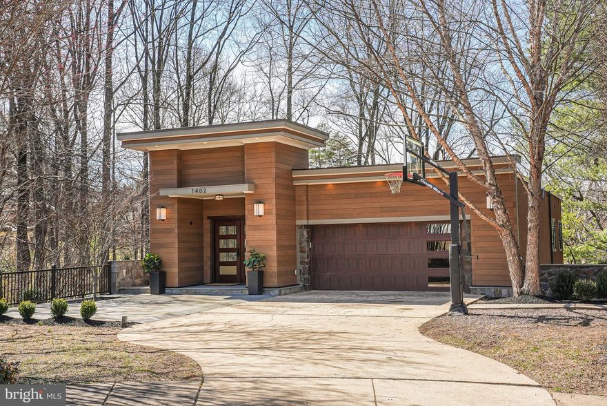 Sophisticated Contemporary Living in the Heart of McLean
Welcome to 1402 Ingeborg Court, a striking five-level contemporary home nestled in highly desirable, close-in McLean. This rare architectural gem seamlessly blends modern elegance with thoughtful design, offering a spacious and light-filled retreat.
Upon arriving, you’ll be greeted by a stunning contemporary exterior featuring a custom garage and front doors. Light is the keyword in this rare and amazing home.  
Enjoy an oversized two-car garage - complete with a built-in EV charger. The garage offers convenient interior access to the entry level, along with a generous storage room that could easily be converted into a mud room or full-sized second laundry room.
A Grand Entrance and Thoughtful Layout
As you enter the front door, you’ll be welcomed into a grand entryway accented by an exquisite natural stone wall – allowing nature to seamlessly join the interior. The entire home has been meticulously refreshed with new paint palette paint, designer carpeting, and refinished engineered and hardwood flooring. 
The entry level offers two well-appointed bedrooms that share an updated full bath with luxury tile and an updated vanity.  One level down, the primary suite awaits—a serene retreat with newly refinished engineered hardwood floors and a two-sided fireplace that enhances both the spacious bedroom and adjacent sitting area. Whether you envision a library, home office, or private lounge, this flexible space adapts to your needs. The primary suite also boasts two extraordinary walk-in closets, two additional outfitted closets, and a luxurious ensuite bathroom with a stunning stone wall, a modern soaking tub, a spacious shower, dual vanities, Quartz countertops, heated floors, and abundant lighting.
This level also includes a newly updated guest’s bath and a well-equipped laundry room.
Expansive Living and Entertaining Spaces
Descending to the next level, you’ll find a breathtaking grand living area with soaring 20+ foot ceilings. A stunning floor-to-ceiling stone fireplace anchors the space, complemented by floor-to-ceiling windows that invite natural light and showcase scenic wooded views. The newly refinished deck offers a seamless indoor-outdoor connection and is perfect for entertaining. Adjacent to the living area, the chef’s kitchen boasts rich wood cabinetry, new chef-style stainless steel appliances, granite countertops, and recessed lighting. 
Private Guest Quarters and Versatile Spaces
The fourth level presents an inviting au pair or in-law suite with a full bath and generous closet space. A window-lined recreation room provides endless possibilities, whether as a media room, playroom, or additional family gathering space. 
On the fifth and final level, a newly redone finished bonus room offers incredible versatility—ideal for an office, playroom, home gym art studio -or possibly a state-of-the-art golf simulator. This space opens directly to the backyard via a newly installed deck - and a brand-new mini-split system ensures year-round comfort.
Sustainability Meets Convenience
This home is equipped with owned solar panels that contribute to energy efficiency, aiding in heating the water heater and reducing utility costs.
Prime Location and Lifestyle Amenities
Situated in a premier McLean location inside the Beltway, this home offers effortless access to major commuter routes with only one traffic light-  including I-495, Route 123, and the GW Parkway. 
Enjoy the best of McLean’s vibrant dining scene, boutique shopping, and cultural attractions. Nearby parks, including Scott’s Run Nature Preserve and Great Falls Park, provide a picturesque escape for outdoor enthusiasts. Additionally, top-rated schools and premier community amenities enhance the unparalleled quality of life in this sought-after area.
A  rare opportunity to own a contemporary masterpiece.
Total Square Footage 5,060