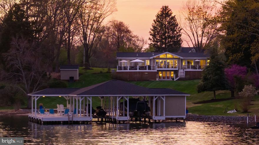 Experience iconic lakefront living in this stunning Lindal Cedar post and beam home, perfectly positioned on the public side of Lake Anna with breathtaking, unobstructed views across the widest stretches of the lake. 140 feet of stone and riprap shoreline, a sandy beach and deep clean water (10 feet at the end of dock), this property offers the ultimate waterfront setting. The impressive double-slip boathouse is designed for both convenience and enjoyment, featuring electric lifts with upgraded motors for both boat and jet ski lifts, WiFi, a spacious partially covered sun deck, and a storage room—everything you need for effortless days on the water. Inside, the home showcases timeless Lindal craftsmanship with vaulted ceilings, exposed beams, a gas stove, and rich maple hardwood flooring. The open-concept layout is filled with natural light and showcases stunning lake views from nearly every room. Offering 3,400 square feet (2,857 finished), this 4-bedroom, 3-bath home is thoughtfully designed for both relaxed everyday living and seamless entertaining. The main-level lakeside primary suite offers private deck access and a beautifully updated ensuite bath with a tiled shower. Two additional lakeside bedrooms also feature direct deck access and share a fully renovated bath. The updated kitchen is equipped with granite countertops, a breakfast bar, stainless steel appliances, and updated lighting in both the kitchen and dining areas. The walkout lower level expands your living space with a spacious family room, fourth bedroom, full bath, and a large storage/workshop area with the potential to be finished for additional living space. Outdoor living is just as impressive, with a newly installed stone seawall and beach area, riprap reinforcement, ambient shoreline and fire pit lighting, and a custom stone fire pit with a Breeo smokeless insert—perfect for unforgettable evenings by the water. Ideally located by both boat and car, you’re just minutes from marinas, local dining, and everyday conveniences. Extensively upgraded and thoughtfully maintained, this home is ready for new beginnings with you! Recent upgrades include new roofs on the house, boathouse, and shed (2021), a whole-house generator (2021), and a new hot water heater (2025). See full list of improvements and items that convey in MLS documents section. HOA is optional to join.