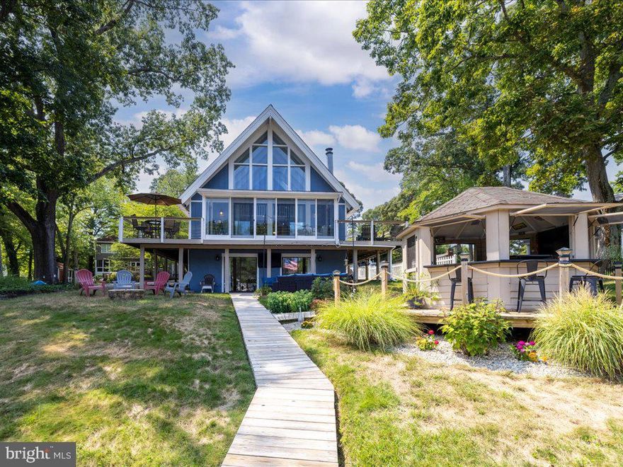 Tucked away along the tranquil banks of Cypress Creek, this inviting A-frame house combines rustic elegance with modern flair, ideal for those who love to entertain. The open-concept living area features vaulted ceilings and panoramic windows that frame the picturesque creek views, while the gourmet kitchen with access to the wrap around porch serves as the heart of the home, perfect for hosting lively gatherings. Step outside onto the expansive deck, where you can enjoy al fresco meals overlooking the water. The highlight of the property is its large private pier, extending gracefully into the creek, offering ample space for docking boats, casting lines, or simply enjoying peaceful moments by the water. The pier can accommodate 4+ boats. Inside, a lower-level game room with a  cozy lounge area ensures that entertainment continues seamlessly, making this home a quintessential haven for both relaxation and celebration. Substantial parking and yard space makes this waterfront home a perfect retreat. Located in the heart of Severna Park you have quick access to Ritchie Hwy, route 50, 100, 10, & Veterans Hwy.  Folger Mckinsey Elementary School, Severna Park Middle School, & Severna Park High School district.