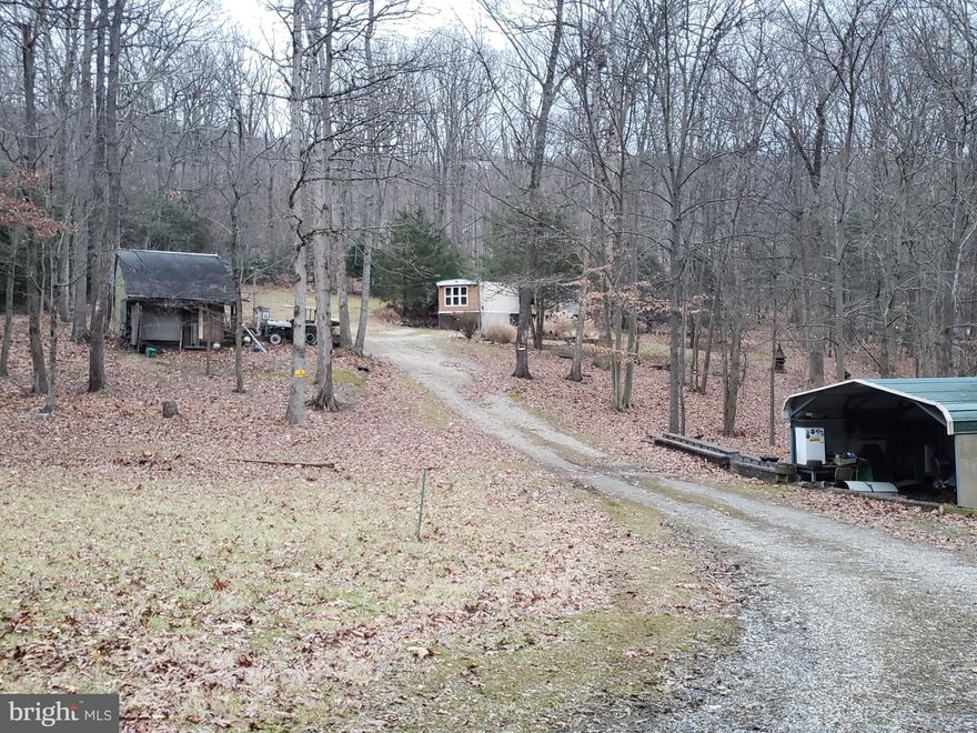 No drive-bys.   Do not go to the property without an appointment.   Cameras at property.  Beautiful and private 3 acre lot with a 2 bedroom, 1 full bath manufactured home including a detached garage and a 2 car carport used for storage. This home is perfect for someone with the cash to purchase and a little extra to make it your own.  The lot is perfect if you are looking to build the home of your dreams by obtaining a new construction loan and removing the manufactured home. Or, perhaps you can find an investor willing and able to lend on a pre- 1976 manufactured home.  This property will not take typical financing.  Please have cash or be qualified with the appropriate loan type. **  Sold as-is where-is including possible personal belongings that may be left.   Handrail at  deck steps to get to front door has deteriorated and steps may be slippery if wet.  Some deck boards have deteriorated. Watch your step.