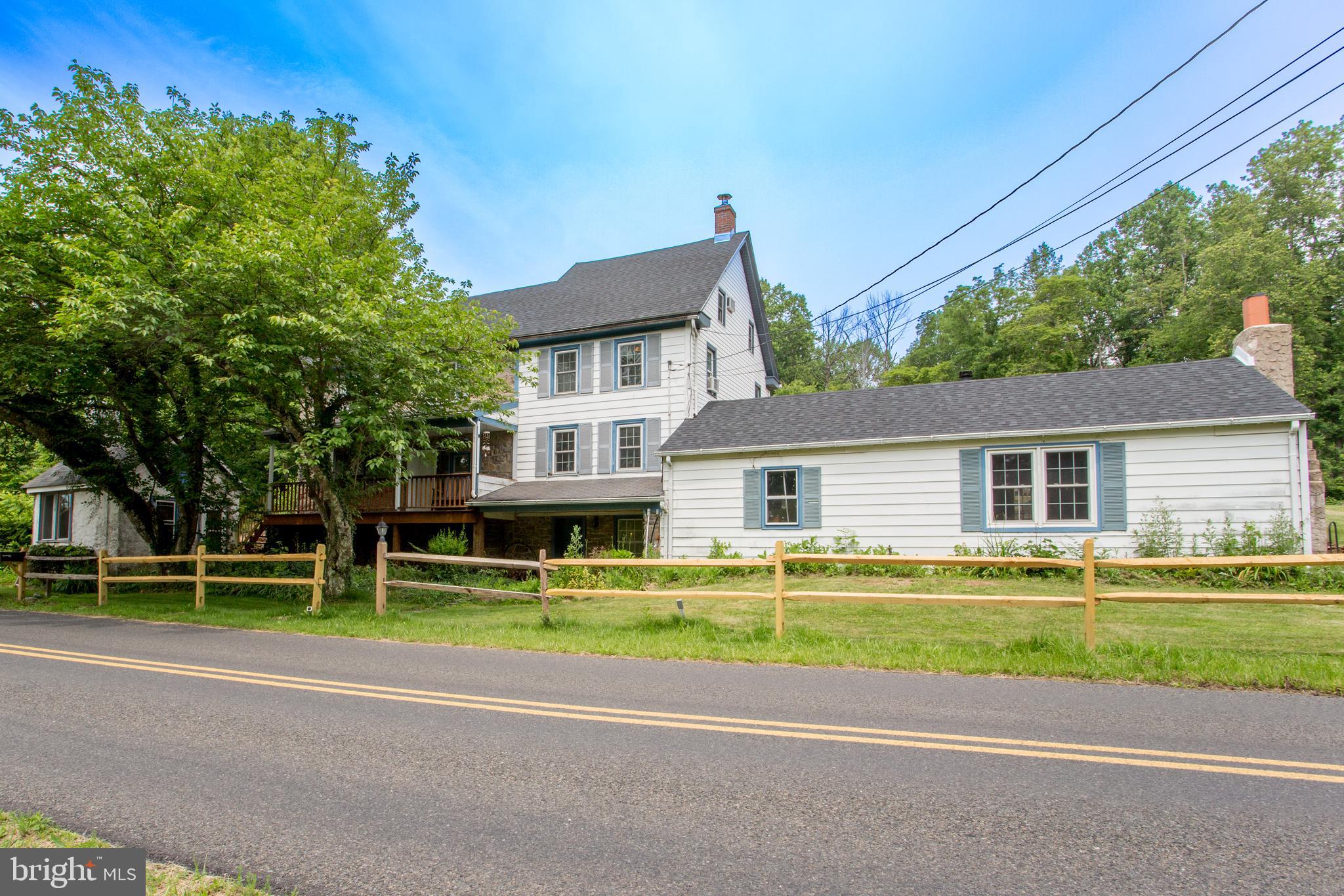 A true piece of Bucks County history and charm. Originally dating back to 1850, this lovely home will
delight you with its’ spaciousness, updates and flexibility while still retaining many of the features and
the original character. The main level consists of the fully remodeled kitchen with granite-counter tops,
tiled backsplash, stainless appliances, beautiful custom cabinets and a maple hardwood floor.
Adjacent to this is the dining room and a few steps down to the amazing Great Room with a cathedral
ceiling, a massive stone fireplace surrounded by built-ins and a free-standing wood stove – perfect for
your own relaxation or large gatherings. There is also a separate laundry room and yet another room
which could be used as a home office or for storage. The family room or sunroom on the back side
gives you even more space and features large windows bathing the area in natural light. The living
room is highlighted by another fireplace, exposed stone wall and beamed ceilings. A half bath
completes this level. Upstairs the primary bedroom is dramatically accented with a beamed ceiling,
exposed stone walls and includes a full primary bath. Two more bedrooms and a full hall bath
complete this level. The upper level includes another bedroom, or a room to use as your needs
dictate. Throughout the home you will be impressed with the exceptional pumpkin pine wide plank
floors, the deep window sills and multiple thoughtful storage areas. The two-story covered porch in
front is a perfect space to enjoy your morning coffee while overlooking your additional parcel of land
across the street with your pond. Continue enjoying the outdoors in the back with the large deck and
dining area as well as the custom built stone firepit to warm the chilly evenings and the in-ground pool
for the warm summer days. The over-sized two car detached garage/workshop provides plenty of
space for a shop or equipment and another large building is the perfect place for a workshop/studio.
Go back in time with the separate “summer kitchen” structure (in as-is condition) which was
previously used as a home office. Lush landscaping will delight you and the roof was replaced in
2025. Ten minutes to Lake Nockamixon State Park. (Two tax parcels included 36-037-009-002 and 36-037-018 for a total of 10 acres). Come discover this treasure and see all that it has to offer!
