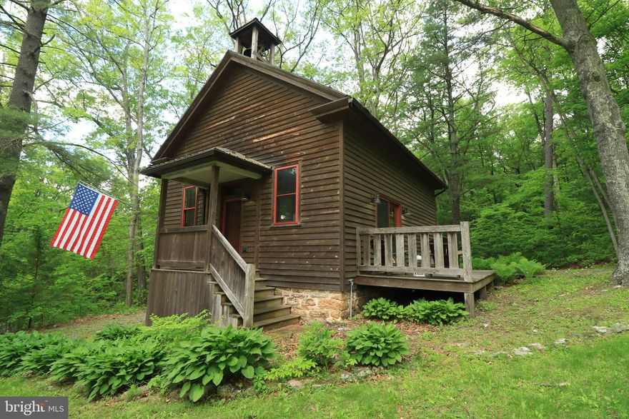 Beautifully renovated by the Amish, this school house turned cabin is as stunning and charming as they get!  Enjoy restored wood flooring, a two story ceiling in the great room, a gorgeous kitchen, and modern amenities in this character filled space.  From the school bell that you can still ring, to the original coat rack and heating grate lights, the old school feel is still here.  The kitchen boasts custom cabinetry and an island with pendant lighting, while the adjacent living room and dining area features plentiful natural light, a ceiling fan, and beadboard walls.  The main floor bedroom has a good sized closet and the connected full bathroom features  laundry machines.  Ascend the super cool rolling library ladder to the second floor loft bedroom that comes completed with a bookshelf with hidden storage attic behind it and a full, attached bathroom.  Relax on the deck taking in the half acre treed lot or head out on a hike into Rothrock State Forest, which abuts the property to the rear.   Sometimes rented as a short term rental with great success, this property could be a primary home, a second home, or a rental.  This property will first be offered to the purchaser of the main home next door at 14467 Greenwood Road and if not purchased by that buyer, offers on this property alone will then be considered.  A short drive to Greenwood Furnace State Park where swimming, fishing, hiking, hunting, biking, and more abounds, and less than 30 minutes to State College and Penn State make this a wonderful, peaceful country retreat that's still close to the action!