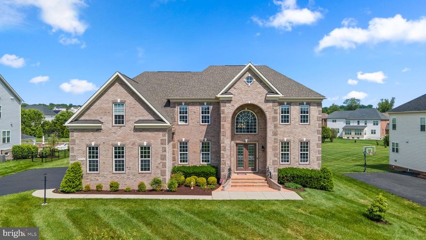 This gorgeous home built in 2020 is sure to impress with enduring curb appeal, spacious open floor plan, grand features, and elegant finishes. Step inside the main level to the astounding foyer with double grand staircases, formal dining room, office or study, family room, kitchen, additional dining space, sunroom, half bathroom, and a guest suite with full bathroom. The large family room boasts a fireplace, high ceilings, a stunning chandelier, ample natural light, and an additional split staircase leading both up and downstairs. A cook’s dream, the gourmet eat-in kitchen is equipped with Kitchen Aid® stainless steel appliances, granite countertops, custom backsplash, a large island with seating and additional cabinetry, 2 sinks, double ovens, a gas range, a wine fridge, a large pantry, and a large sunroom with custom crown molding and recessed lights. Retreat to the luxurious owner’s suite with a spa-like bathroom and 3 walk-in closets. 3 additional bedrooms with en-suite bathrooms including 1 buddy bath reside on the upper level. The finished lower level hosts a large open rec room, bonus room, full bathroom, additional bedroom, and unfinished space for storage. A 3-car garage boasts space for vehicles or tools and a 220 EV car charger in the garage. Large deck overlooking the meticulously landscaped large and flat backyard with sprinkler system. Enjoy peace of mind with the security system installed at every doorway and window. This sought-after community offers proximity to dining and shopping on Route 40, nearby access to Highway 70, 29, and 695, and a short drive to BWI Airport for a weekend getaway.