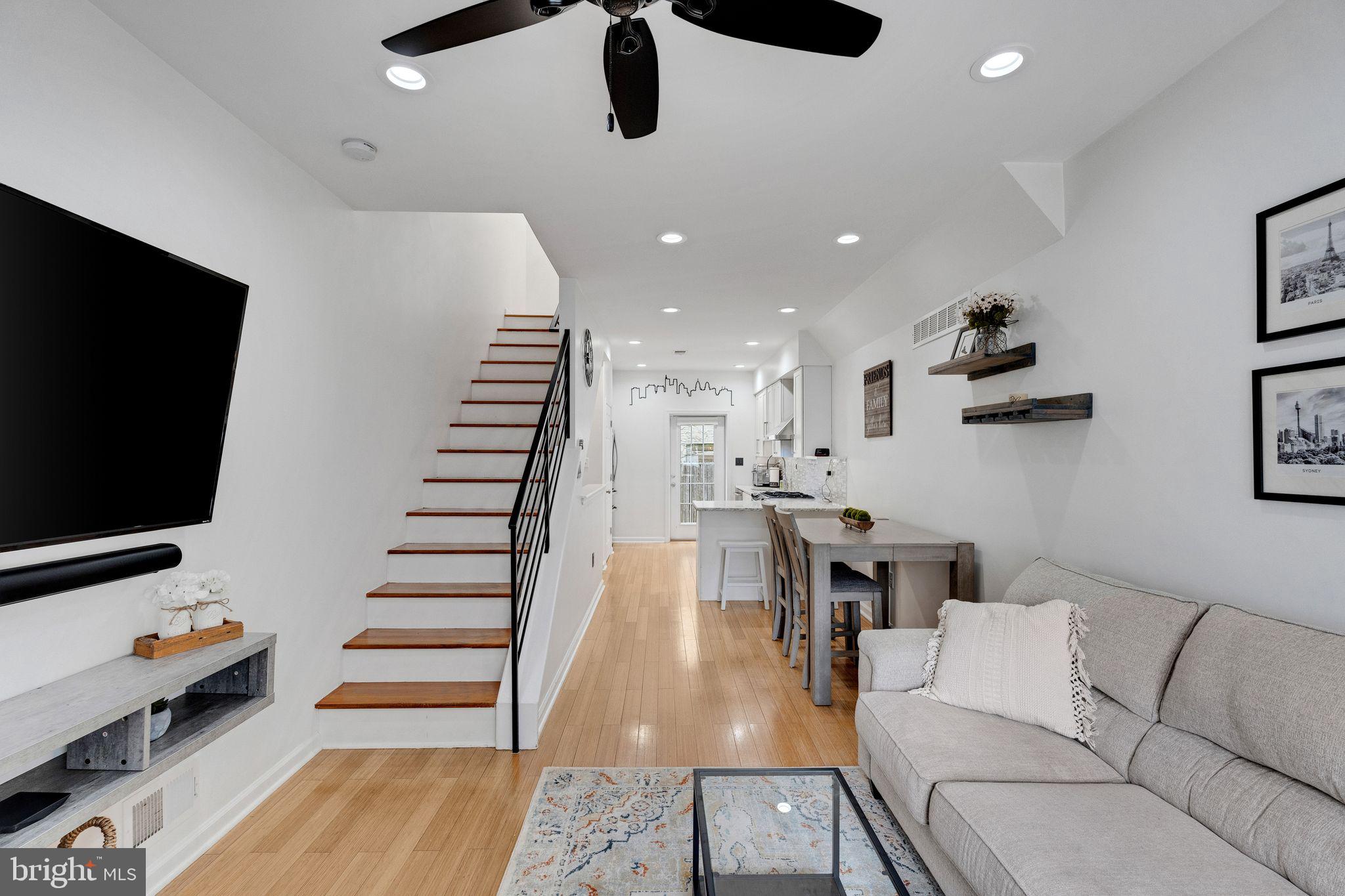 This beautifully maintained and updated home, built in 2009, offers an open floor plan with 3 bedrooms, a finished lower level, and a private rooftop deck with sweeping skyline views. It’s located on a quiet, tree-lined block in the highly sought-after Marian Anderson Neighborhood Academy catchment in Graduate Hospital. The home feels larger than the square footage suggests, thanks to abundant natural light, high ceilings, and thoughtful design. The living area features light hardwood floors that continue throughout the home and comfortably accommodates a nicely sized sectional without sacrificing space for a separate dining area. The kitchen completes this level with a large custom pantry closet, stainless steel appliances—including a 6-burner slide-in range with hood—quartz countertops with breakfast bar, and plenty of storage within the white Shaker-style cabinetry. Head out back to the first of two private outdoor spaces: the rear patio, perfect for a grill or small bistro set. Upstairs on the second floor, you'll find two bedrooms, each with ceiling fans, closets, and oversized windows. They share a full hallway bath with a modern white vanity and tile floors. The Samsung Steam HE washer and moisture-sensing dryer are also conveniently located on this level, saving you trips down to the basement. The third-floor primary suite is a true retreat. The expansive bedroom features two closets, high ceilings with a ceiling fan, and large front-facing windows. The ensuite bath includes a granite-topped vanity and a glass-enclosed walk-in shower with custom tilework. Just opposite the bedroom, you can step out onto your private rooftop deck—the perfect place to sip your morning coffee or watch the sunset. Downstairs, the fully finished lower level offers versatile living space, currently set up as a multipurpose gym and lounge, with a stylish powder room and additional storage at the back with two large closets and a utility closet. At 1903 Webster Street you are perfectly situated to enjoy the best of Philly- head north to Rittenhouse, southeast to Passyunk Square, or stay local with neighborhood and enjoy favorites like Sidecar Bar & Grill, Ultimo Coffee, or Loco Pez.