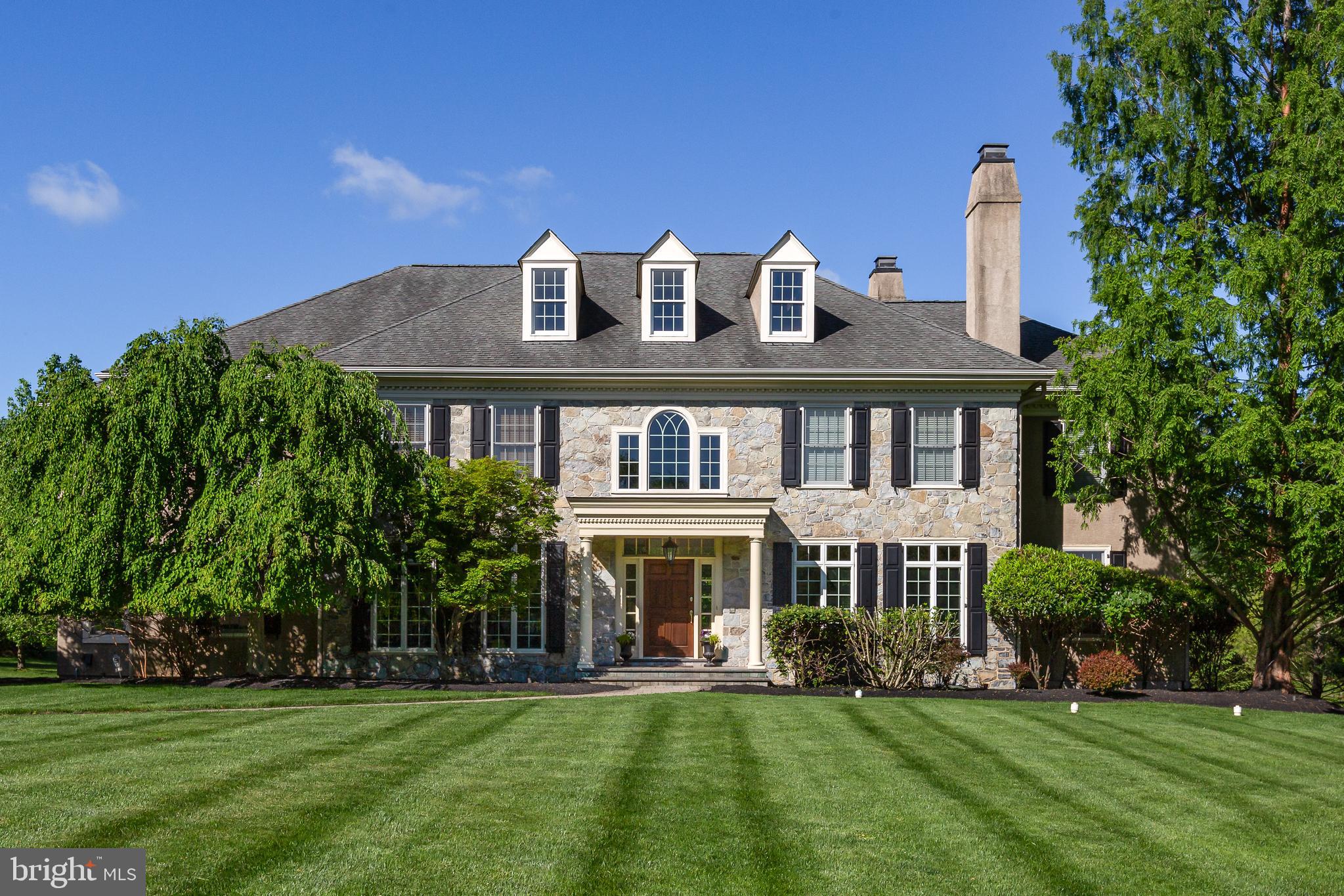 Welcome to 211 Twinings Lane, in the highly-sought after Whitegate community of Wayne. Constructed by Bentley Homes, the owners have spared no attention to detail, adding numerous builder upgrades. The tree-lined street meanders through the community and leads to this manor-style home on a tranquil cul-de-sac lot. A sweeping front lawn and impressive stone facade highlight the timeless elegance of this home.
Upon entering, a two-story center hall is highlighted on either side by arched doorways with beautiful casework leading to the living and formal dining rooms. An open staircase to the second floor and a wide center hall create a classic front-to-back flow. Red oak hardwood floors and wainscotting throughout unify the first floor. The grand staircase to the second floor accents the great room with its soaring windows and hearth-to-ceiling stone fireplace. A sunroom with a tile floor is located off the great room. A cozy room to relax in and enjoy the natural light pouring in from the many windows. The study with built-in cherry wood bookshelves, doors, and windows offers a quiet space for working from home or reading a book.
The open and spacious gourmet kitchen is a few steps from the great room. The oversized granite-topped island and abundant custom cabinetry are a few of the many upgrades that create this chef-style kitchen. Upgraded appliances include a warming drawer and wine cooler as well as a newly installed touch faucet for added convenience. A classic breakfast room with three sides of windows and access to the spacious patio allows for informal dining indoors or out. A large mudroom, including built-in storage and one of two main level powder rooms, leads one from the attached garage into the kitchen. A second powder room centrally located for guests’ use completes the main level.
The second floor, accessed by the front or back stairs, boasts a wide hall open to the soaring windows of the great room. There are five bedrooms and three baths on this level. Entry to the primary suite is through French doors and a vestibule. The primary suite includes a spacious bedroom, a flexible space which can be used as a sitting room or dressing room with two large, custom closets and an en suite bathroom. The primary bath includes a soaking tub, walk-in shower, and a long vanity with dual his-and-her sinks. An open hall leads to 4 large bedrooms with custom closets and Jack-and-Jill baths. A laundry room with counter space and a window allowing natural light completes the second floor. Head upstairs once again to find a partially finished space on the third level with endless possibilities for your customization.
Upgrades added to this home during construction include sound insulation of the primary suite, house alarm system, lawn sprinkler system, gas fireplace, gas line to patio, full unfinished basement with French door access to outdoor concrete stairs to grade, upgraded cabinetry, woodwork, and hardware throughout.
The coveted Whitegate community has a playground and tennis courts for residents' enjoyment, and the Wayne location is convenient to all the Main Line has to offer!